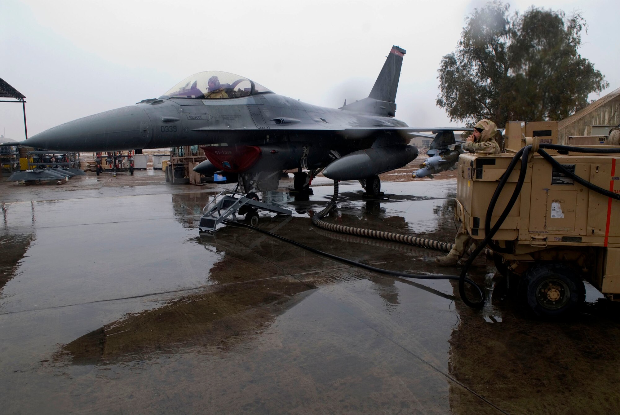 Staff Sgt. Jeremy Crombie talks to Senior Airman Trevor Scott via radio headsets during a Global Positioning System test for a F-16 Fighting Falcon Jan. 11 at Balad Air Base, Iraq. The daily test ensures the system is working properly. Sergeant Crombie and Airman Scott are 332nd Expeditionary Aircraft Maintenance Unit avionics technicians deployed from Spangdahlem Air Base, Germany. (U.S. Air Force photo/Staff Sgt. Joshua Garcia) 
