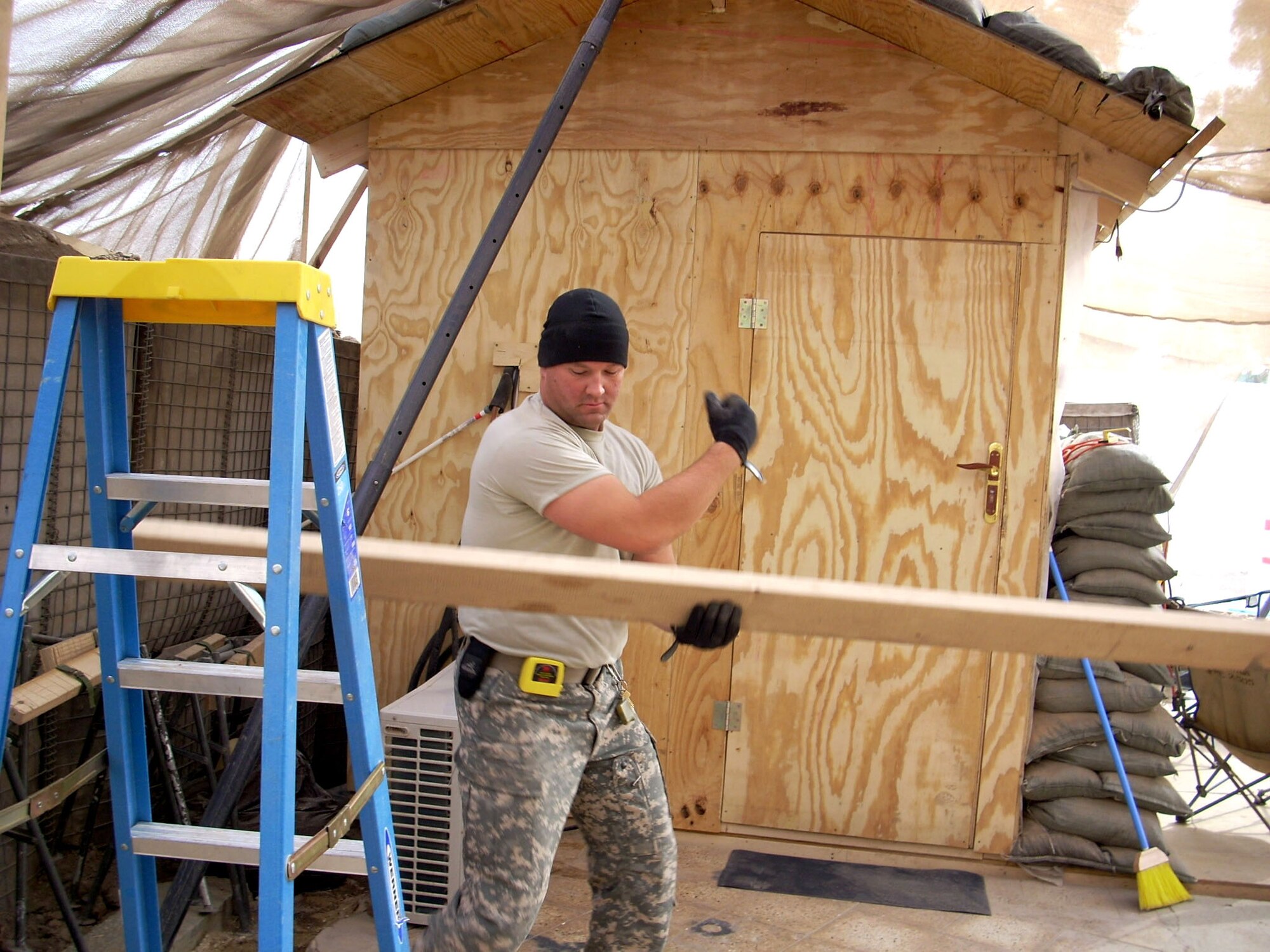 Tech. Sgt. Greg Bass carries lumber for the construction of the triage overhang Jan. 11 at Patrol Base Olson, Iraq. Sergeant Bass, a 732nd Expeditionary Civil Engineer Squadron Det. 6 structural technician, is deployed from Kadena Air Base, Japan. (U.S. Air Force photo) 
