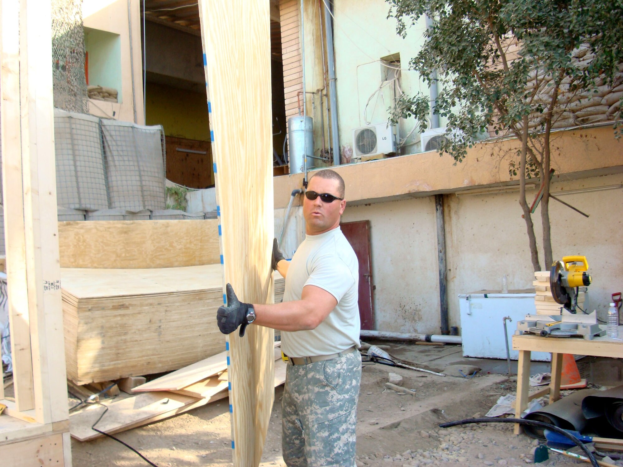 Tech. Sgt. Greg Bass carries plywood used to construct a housing unit Jan. 11 at Patrol Base Olson, Iraq. Sergeant Bass, a 732nd Expeditionary Civil Engineer Squadron Det. 6 structural technician, is deployed from Kadena Air Base, Japan. (U.S. Air Force photo) 

