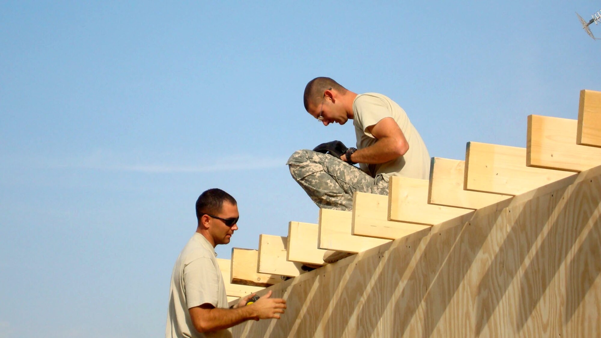 Staff Sgt. Michael Shaffer (left) Airman 1st Class Bradley Hambleton measure the distance between two rafters before completing the roof of a housing unit Jan. 11 at Patrol Base Olson, Iraq. Airman Hambleton is deployed from Kadena Air Base, Japan, and Sergeant Shaffer is deployed from Beale Air Force Base, Calif. Both are 732nd Expeditionary Civil Engineer Squadron Det. 6 structural technicians. (U.S Air Force photo) 
