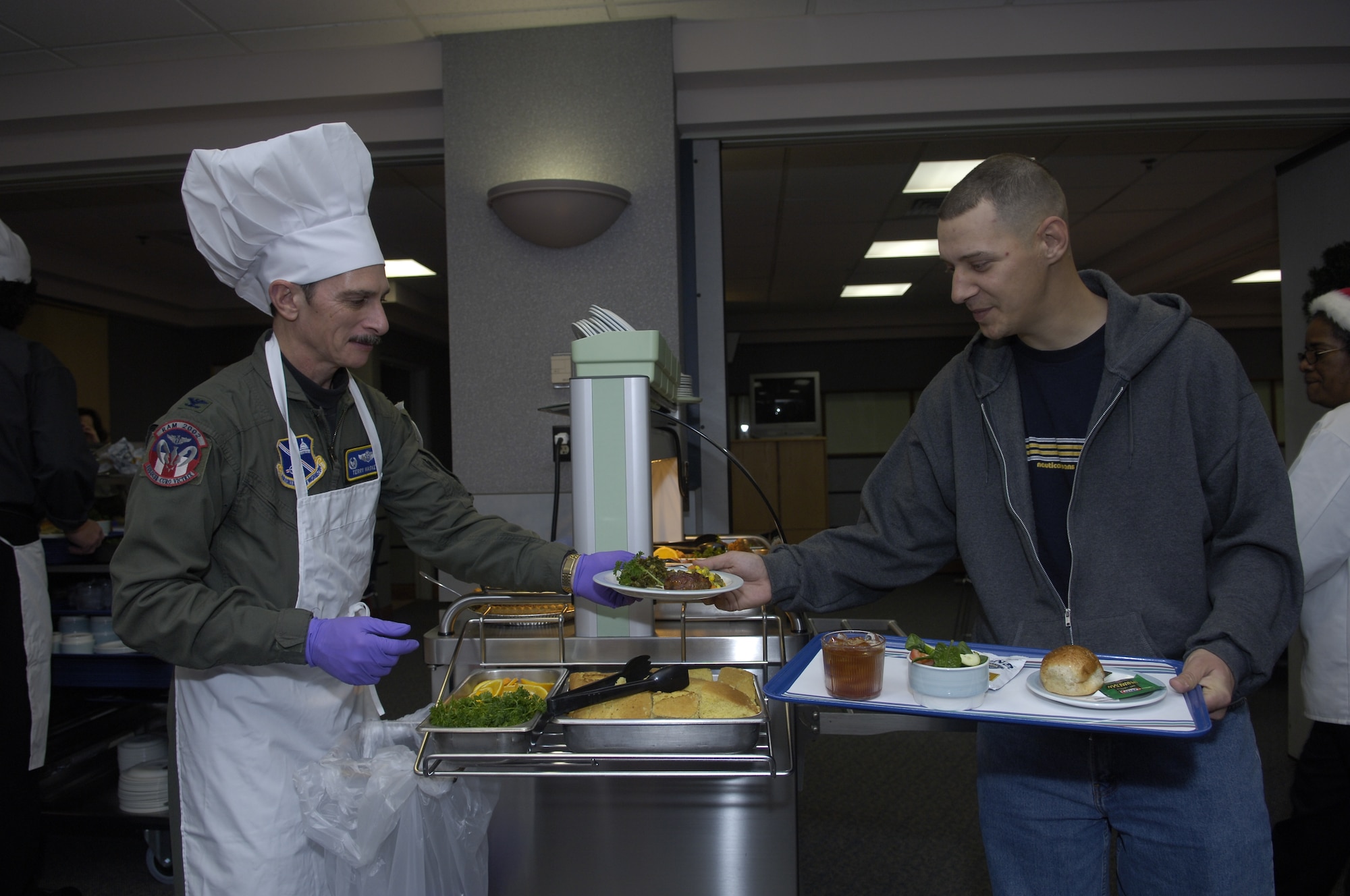 Air Force Staff Sgt. David Webb receives his Christmas dinner from Col. Terry Haske, 79th Aerospace Medicine Squadron Commander, at the Aeromedical Staging Facility here Dec. 25, 2007. Sergeant Webb is enroute to Vance Air Force Base, Okla. from Balad Air Base, Iraq.
(US Air Force/SrA Renae Kleckner)