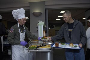 Air Force Staff Sgt. David Webb receives his Christmas dinner from Col. Terry Haske, 79th Aerospace Medicine Squadron Commander, at the Aeromedical Staging Facility here Dec. 25, 2007. Sergeant Webb is enroute to Vance Air Force Base, Okla. from Balad Air Base, Iraq.
(US Air Force/SrA Renae Kleckner)