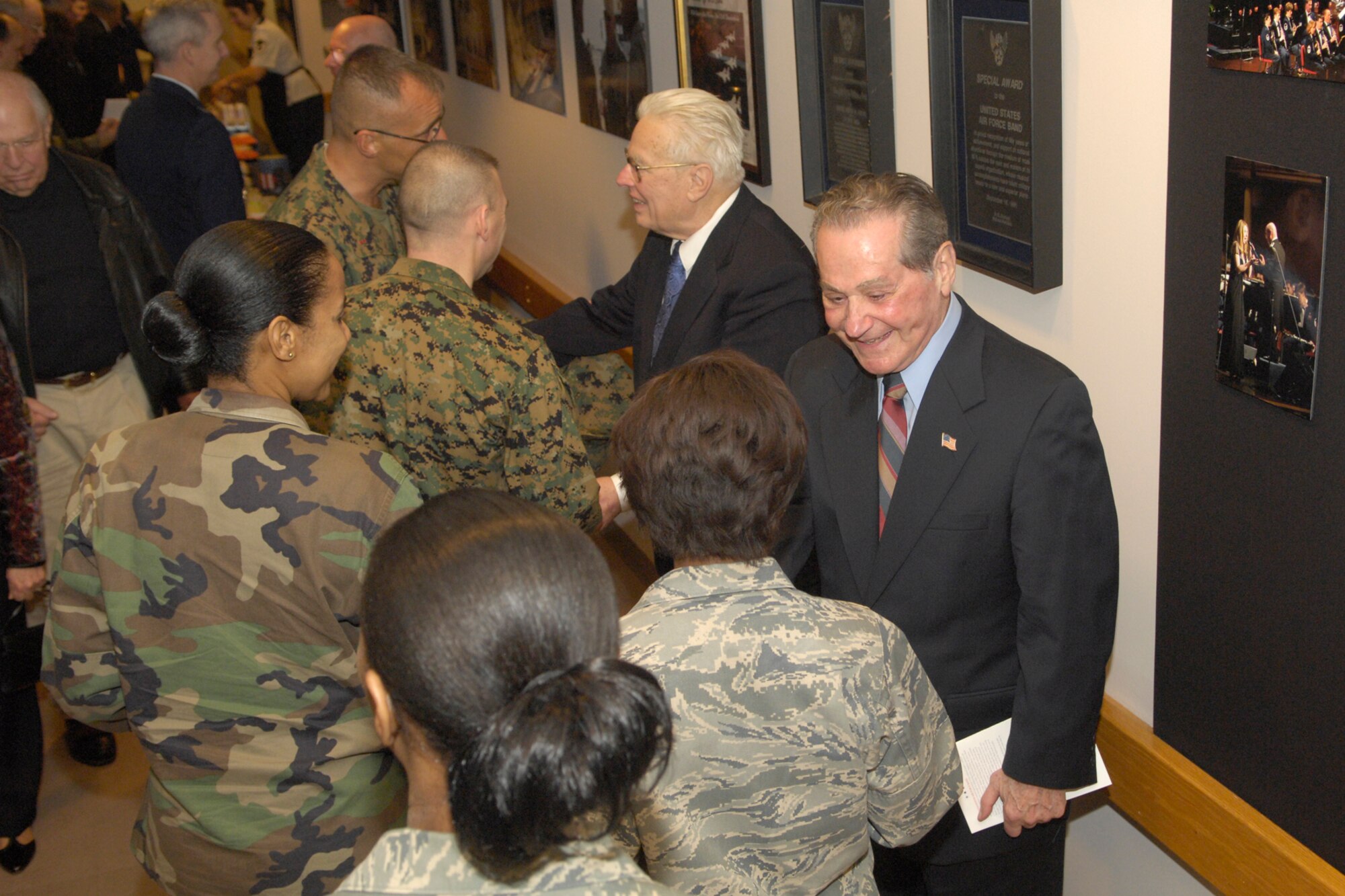 Retired Chief Master Sgt. Floyd Werle, U.S. Air Force Band composer and arranger emeritus (above) and Retired Col. Arnald Gabriel, conductor emeritus, receive congratulations from friends and Band members following the dual-room dedication ceremony Jan. 9 at Hangar 2. (U.S. Air Force photo by Airman 1st Class Sean Adams.)