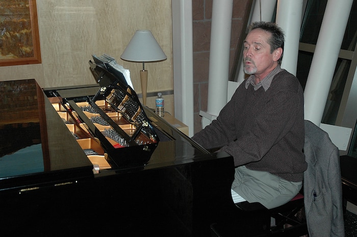 Terry Morris, 532nd Landing Gear Squadron Director, sings and plays a nine-foot Yamaha grand piano at the McKay-Dee Hospital Center in Ogden. Mr. Morris is part of the McKay-Dee Piano Guild, a volunteer organization with more than 80 members, several of which are from Hill Air Force Base. (U.S. Air Force Photo by Fred Schoettler)
