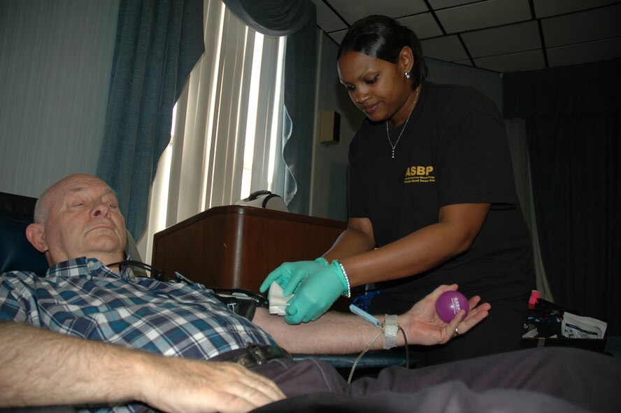 Cookie Thompson, 81st Medical Operations Squadron medical lab technician, prepares John Sitten, retired Army lieutenant colonel and current Air Force Civil Engineer Support Agency contractor, for his blood donation at the Community Activities Center Wednesday.  A total of 77 people arrived at the CAC to donate blood in support of the Armed Services Blood Program.  (U.S. Air Force photo/Staff Sgt. Timothy R. Capling)