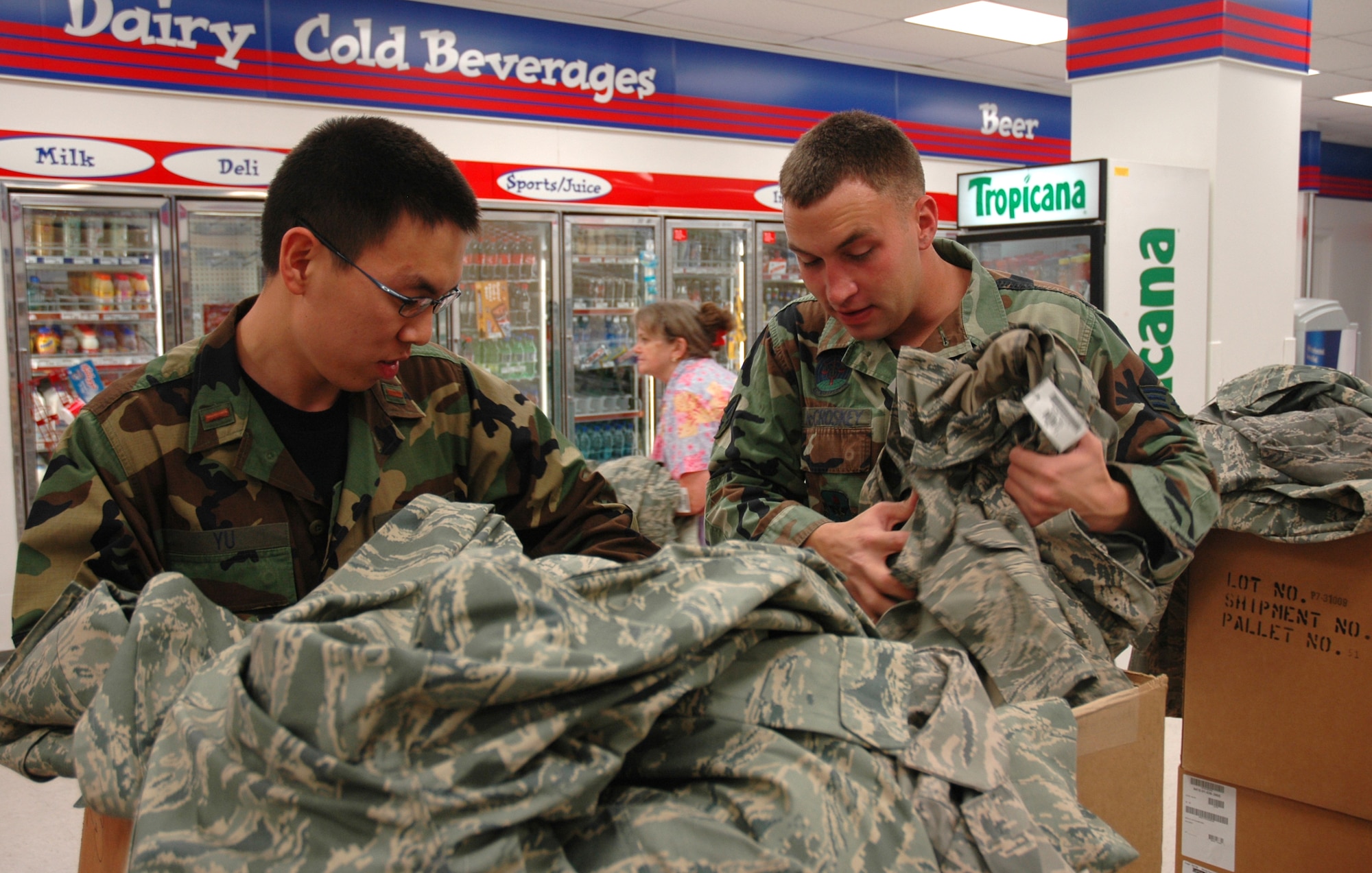 Second Lieutenant David Yu, 325th Air Control Squadron student, and Senior Airman Dustin McCroskey, 325th Security Forces Squadron patrolman, search through a box of the Airman Battle Uniforms at Military Clothing Sales Wednesday.  Military Clothing Sales management hopes to get another shipment of the uniform in February.  (U.S. Air Force photo/Staff Sgt. Timothy R. Capling)