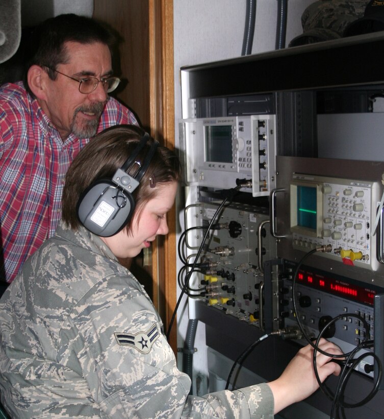 Barry Booth, 346th Test Squadron, EMSEC test manager leads Airman 1st Class Michelle Wallen, 346th Test Squadron, EMSEC technician through measurement and recording of a signal of interest during a recent TEMPEST test of a laptop computer intended for use in classified system.