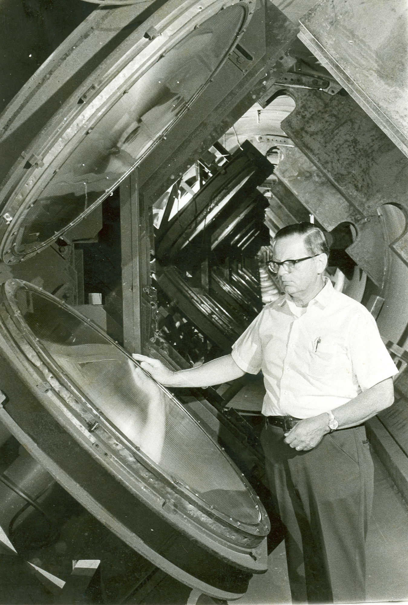 Otto Bock of Brentwood, Tenn., is shown inside the 1,000-foot underground Hypervelocity Ballistic Range G, at AEDC's von Karman Facility. He played a major role in designing many of the optical data systems used in the range. He takes a last look before retiring May 28, 1976 at the huge Fresnel lenses that are part of a shadowgraph system that is able to take “stop action” photos of models as they speed down range at up to 14,000 miles an hour. (USAF-AEDC file photo)