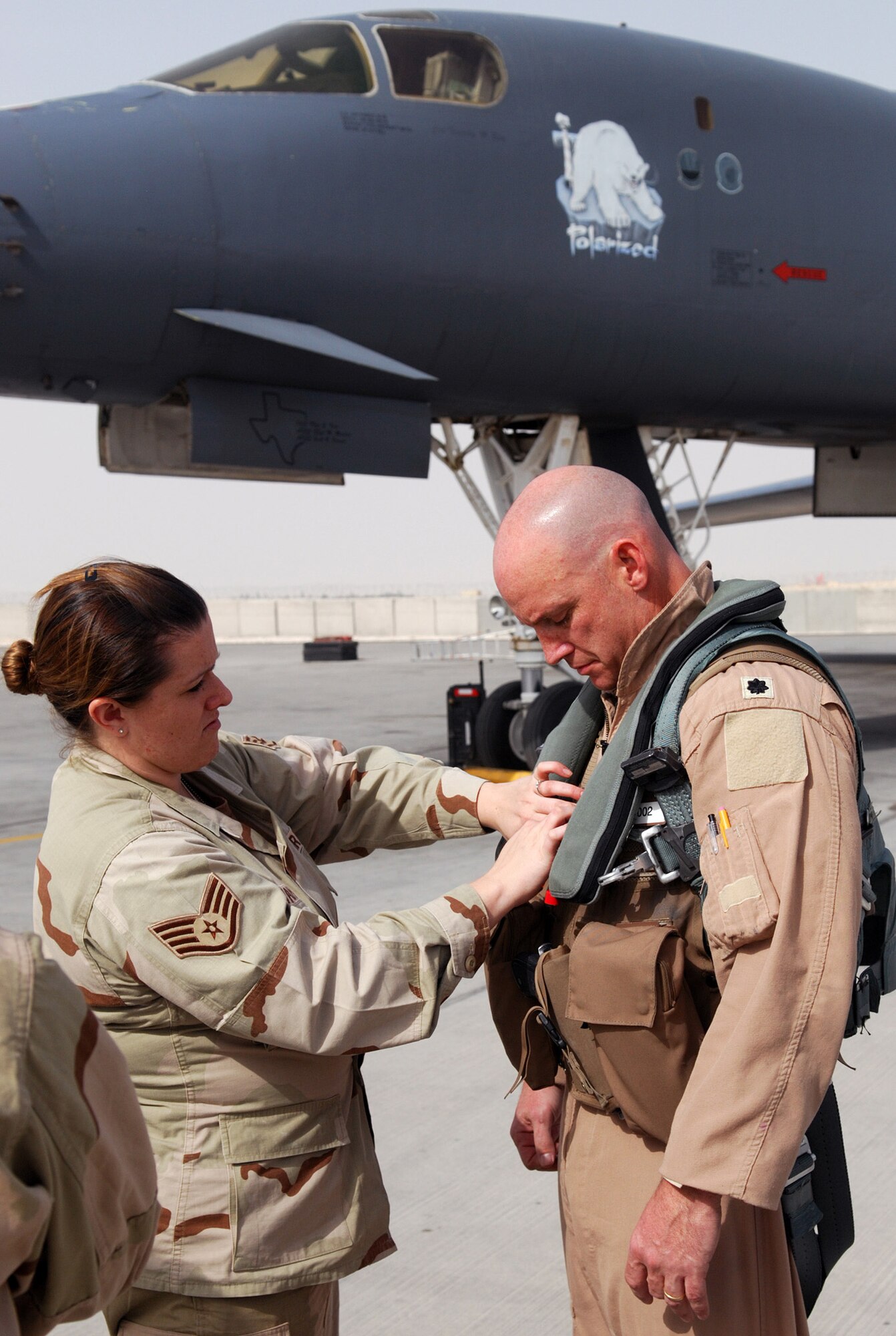 SOUTHWEST ASIA - Staff Sgt. Laura Latham, 379th Air Expeditionary Wing Public Affairs, 'mikes' LT. Col. Michael Eliason in preparation for a video tape interview at a Southwest Asia air base Jan. 10. Colonel Eliason, 9th Expeditionary Bomb Squadron commander, has just returned from a two-ship B-1B Lancer strike in Iraq in support of the U.S. Army. (U. S. Air Force photo/Staff Sgt. Douglas Olsen)