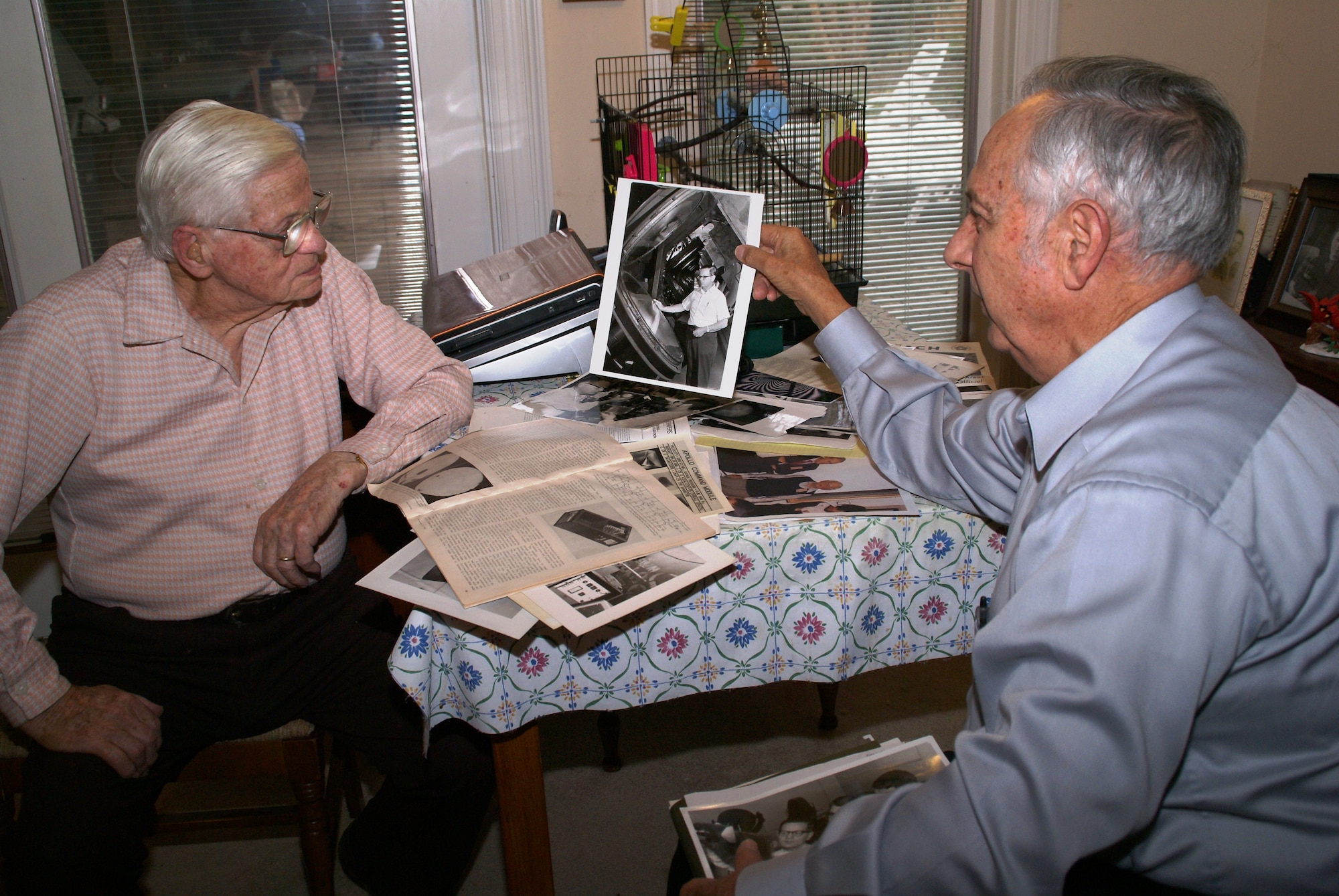 Former AEDCers, Otto Bock and John Hill, share memories and old photos of their collaboration at AEDC over the years. They are good friends and enjoy getting together on occasion to socialize and discuss highlights from their successful efforts to improve the Hypervelocity Ballistic Range G at AEDC's von Karman Facility. Among other contributions, Hill designed and developed the laser-illumination photo system still in use at the facility. (Photo by Philip Lorenz III)