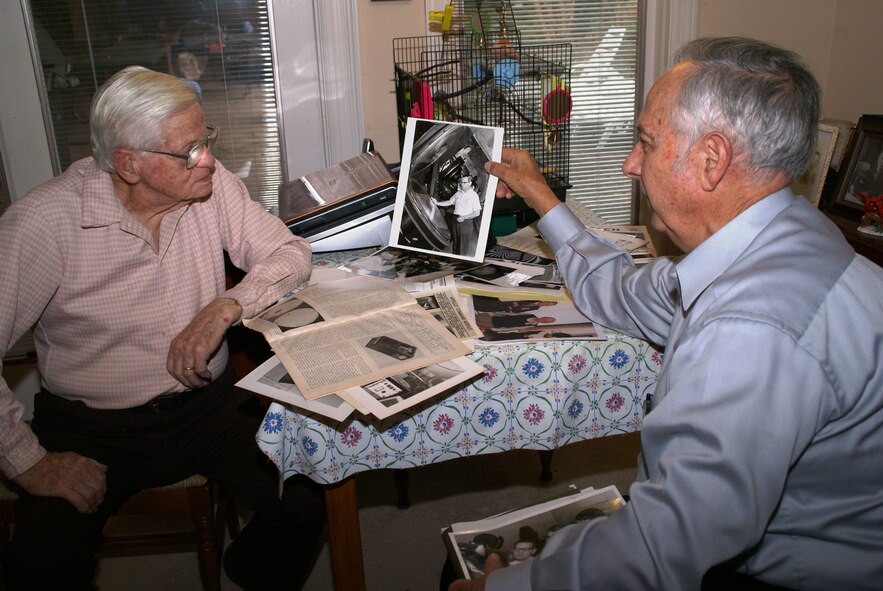 Former AEDCers, Otto Bock and John Hill, share memories and old photos of their collaboration at AEDC over the years. They are good friends and enjoy getting together on occasion to socialize and discuss highlights from their successful efforts to improve the Hypervelocity Ballistic Range G at AEDC's von Karman Facility. Among other contributions, Hill designed and developed the laser-illumination photo system still in use at the facility. (Photo by Philip Lorenz III)