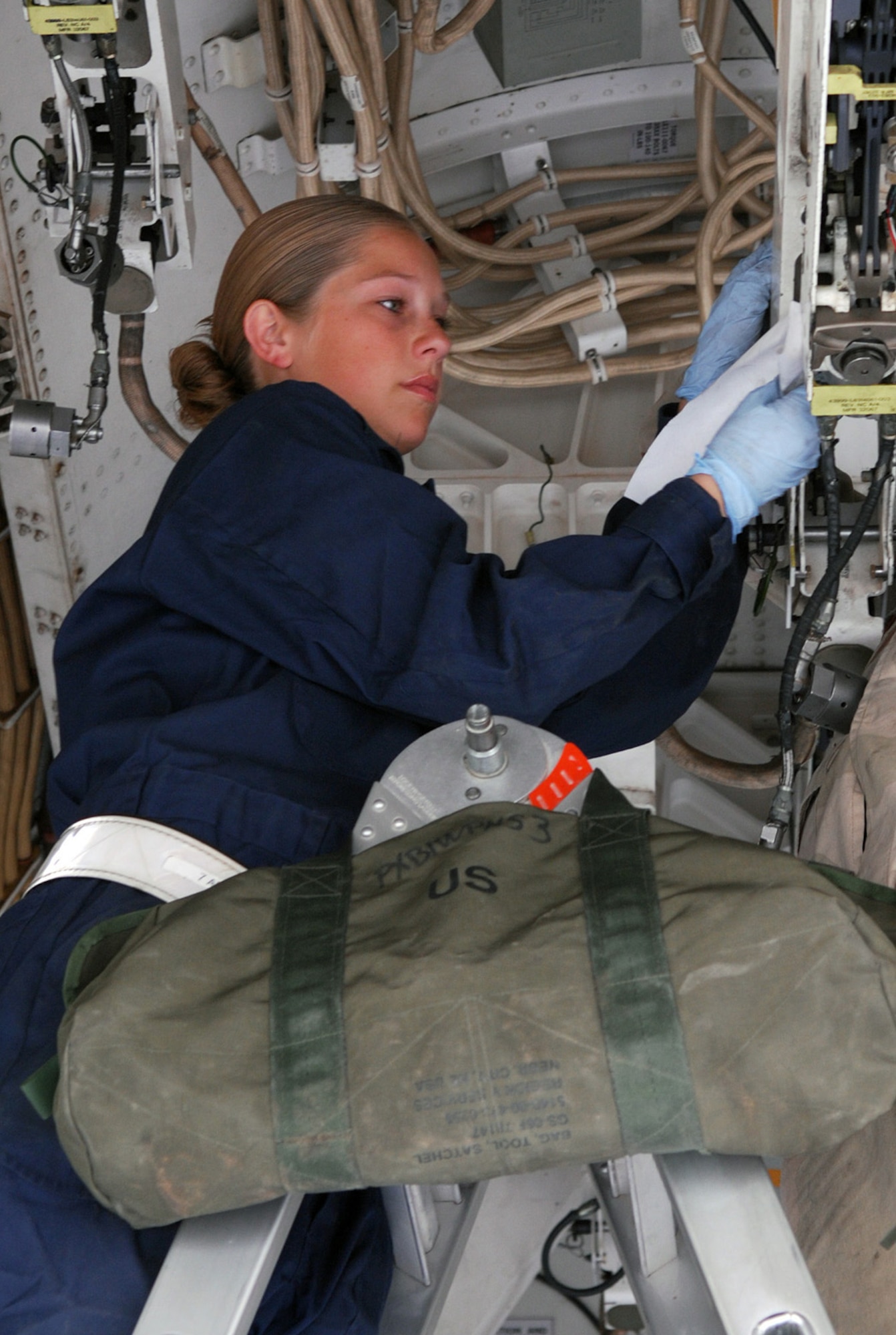 SOUTHWEST ASIA - Airman 1st Class Marjorie Carr, 379th Expeditionary Aircraft Maintenance Squadron, cleans the ordnance racks in the bomb bay of a B-1B Lancer Jan. 10 at a Soutwest Asia air base. The bomber has just returned from a mission. Airman Carr's home station is Dyess Air Force Base, Texas, and her home town is Grand Junction, Colo. (U. S. Air Force photo/Staff Sgt. Douglas Olsen)