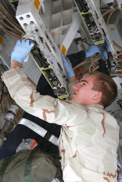 SOUTHWEST ASIA - Airman 1st Class David Pownell, 379th Expeditionary Aircraft Maintenance Squadron, cleans the ordnance racks in the bomb bay of a B-1B Lancer Jan. 10 at a Southwest Asia air base. The bomber has just returned from a mission over Iraq. Airman Pownell is home stationed at Dyess Air Force Base, Texas, and his home town is Appleton, Wisc. (U. S. Air Force photo/Staff Sgt. Douglas Olsen)
