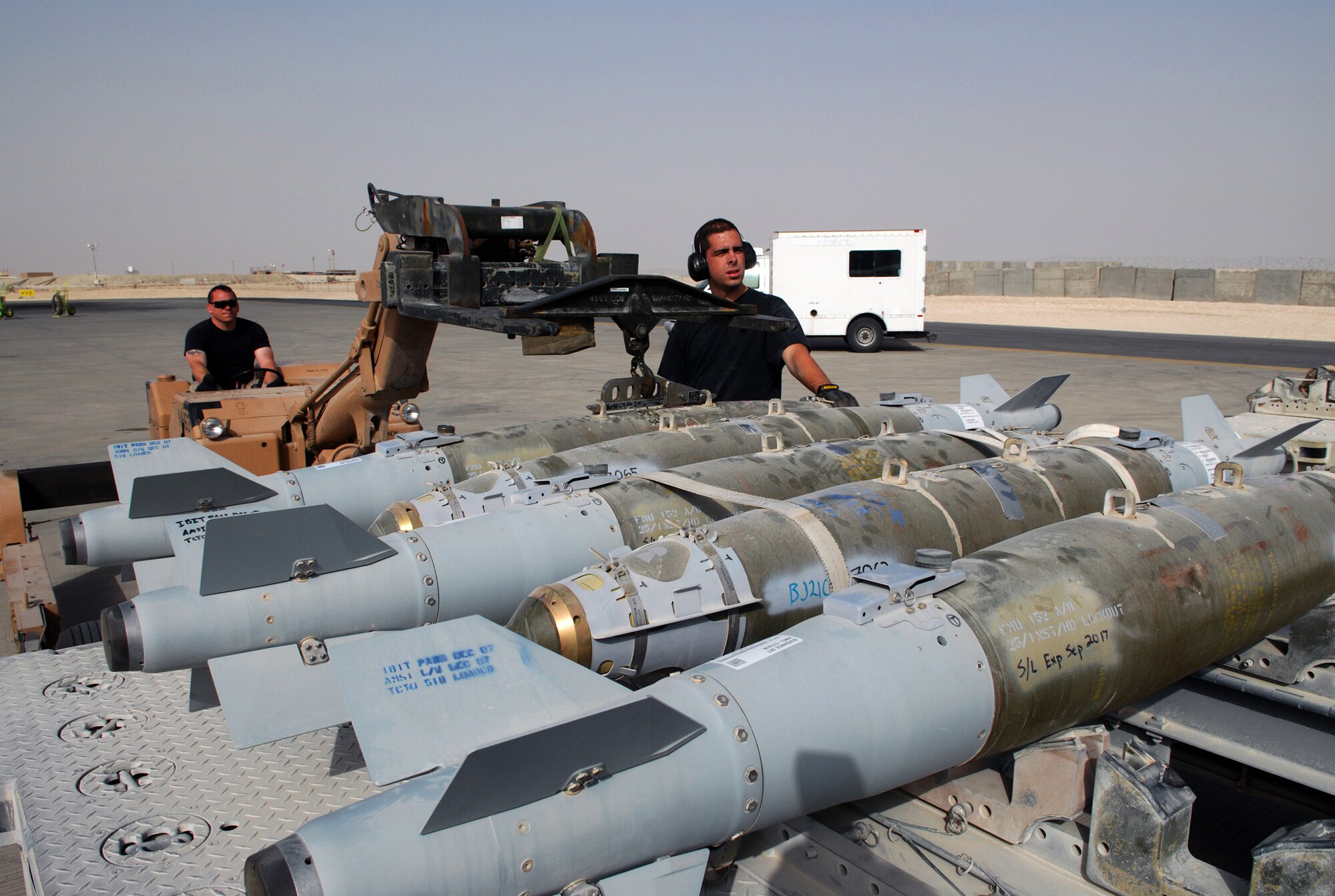 SOUTHWEST ASIA - Senior Airman Brett Williamson, guides Staff Sgt. Greg Eaton as they move ordnance to load a B-1B Lancer Jan. 10 at a Southwest Asia air base. Both airmen are assigned to the 379th Expeditionary Maintenance Squadron. (U. S. Air Force photo/Staff Sgt. Douglas Olsen)