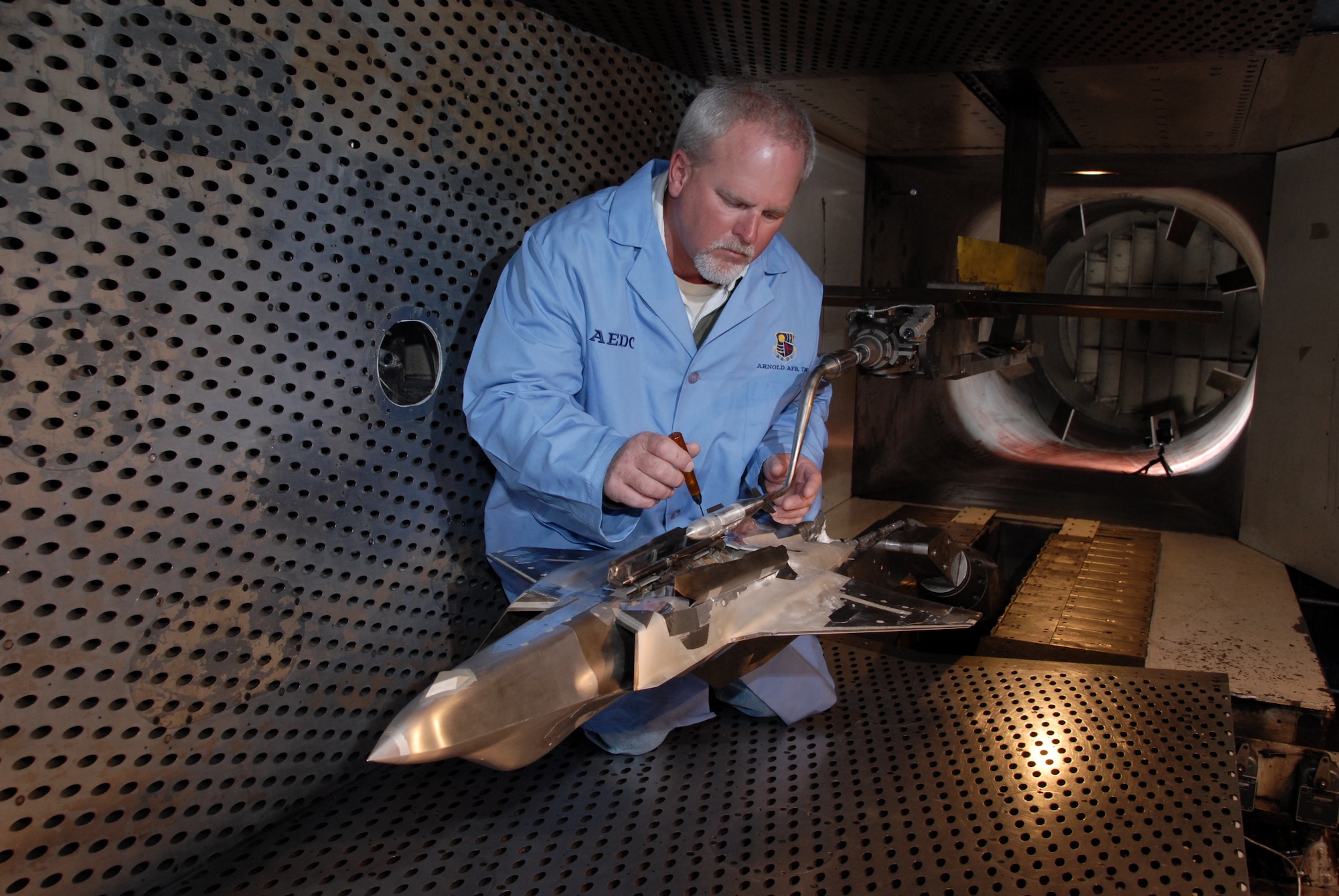 Aerospace Testing Alliance (ATA) Outside Machinist Jim Lynch makes adjustments to a model of a GBU-31 Joint Direct Attack Munition (JDAM) before F-35 Lightning II store separation testing resumed in Arnold Engineering Development's (AEDC) four-foot transonic wind tunnel. ATA is the support contractor at AEDC. (Photo by Rick Goodfriend)