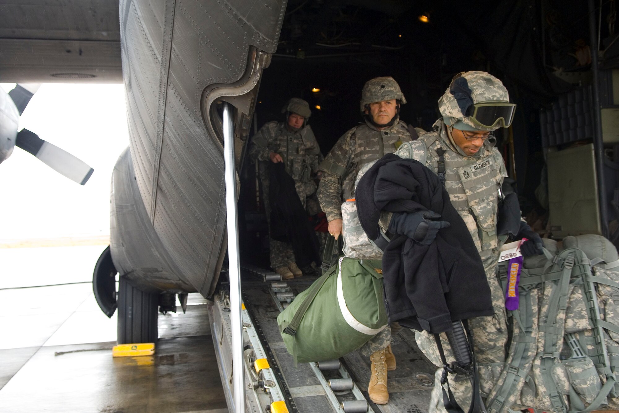BALAD AIR BASE, Iraq -- Airmen and Soldiers exit a C-130 that landed here, Jan. 11. The C-130s main mission in Iraq is to provide precision air delivery of supplies and personnel throughout the theater of operations. (U.S. Air Force photo/Staff Sgt. Travis Edwards)