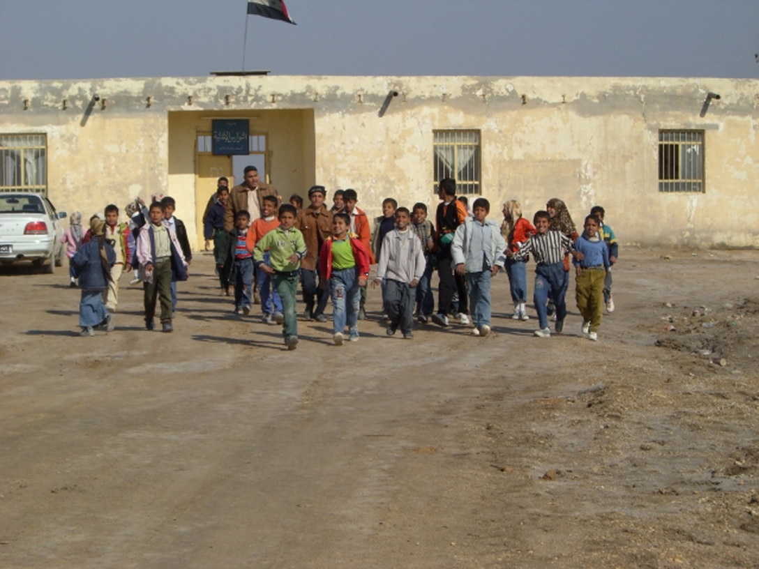 ALI AIR BASE, Iraq -- Iraqi children run with excitement toward Air Force Special Agents who brought school supplies and toys Dec. 29 to the village near An Nasiriyah. In just over a month, Airmen of the 407th Air Expeditionary Group collected thousands of school supply items, soccer balls, stuffed animals and toys from back home for the base's Operation Iraqi Child program. (Courtesy Photo)