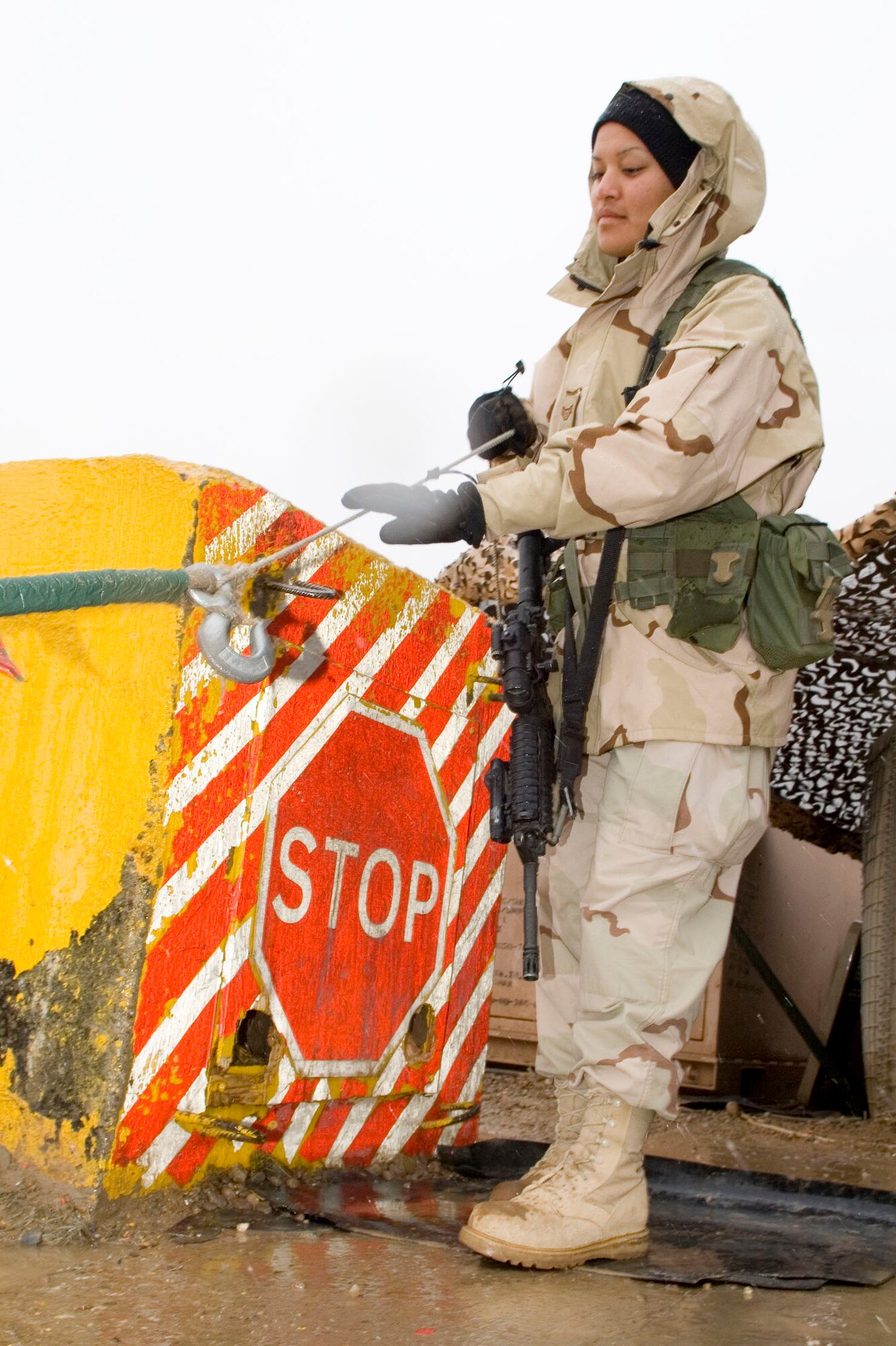BALAD AIR BASE, Iraq -- Airman 1st Class Raylene Thomas, a 332nd Expeditionary Security Forces Squadron entry control point guard, drops a line to allow a vehicle to enter Air Force housing here, Jan. 11. Airman Thomas is deployed from Spangdahlem Air Base, Germany. (U.S. Air Force photo/Staff Sgt. Travis Edwards)