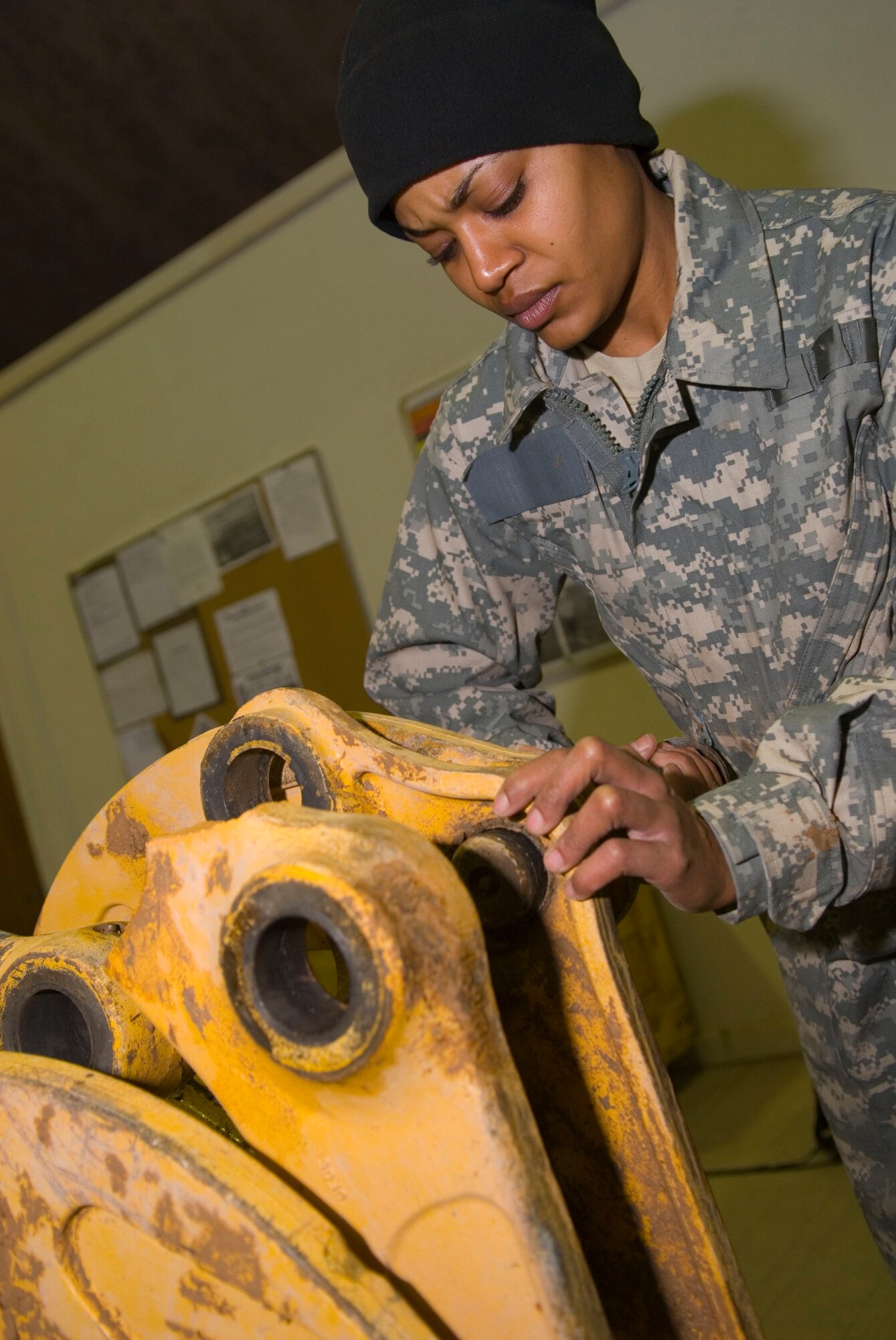 BALAD AIR BASE, Iraq -- Staff Sgt. Tina Ivory, a 332nd Expeditionary Logistics Readiness Squadron vehicle maintainer, replaces a damaged arm on a backhoe here, Jan. 11. Vehicle maintainers ensure the readiness of all transportation vehicles on base. Sergeant Ivory is deployed from Andrews Air Force Base, Md. (U.S. Air Force photo/Staff Sgt. Joshua Garcia)