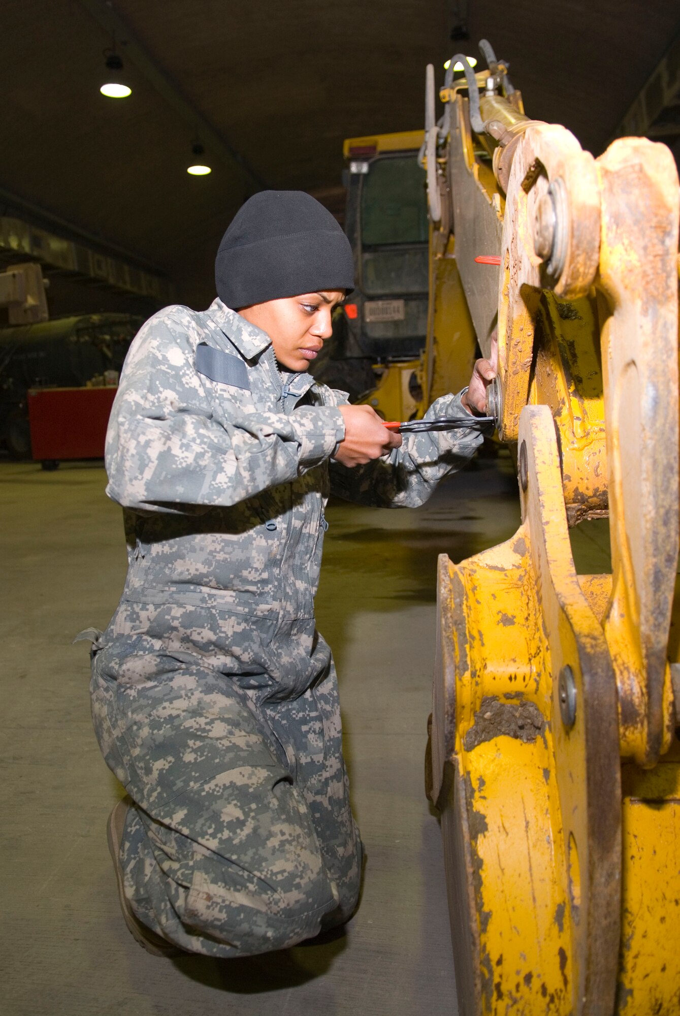 BALAD AIR BASE, Iraq -- Staff Sgt. Tina Ivory, a 332nd Expeditionary Logistics Readiness Squadron vehicle maintainer, removes snap rings from a backhoe here, Jan. 11. The rings aid in holding parts in place on the vehicle. Sergeant Ivory is deployed from Andrews Air Force Base, Md. (U.S. Air Force photo/Staff Sgt. Joshua Garcia)