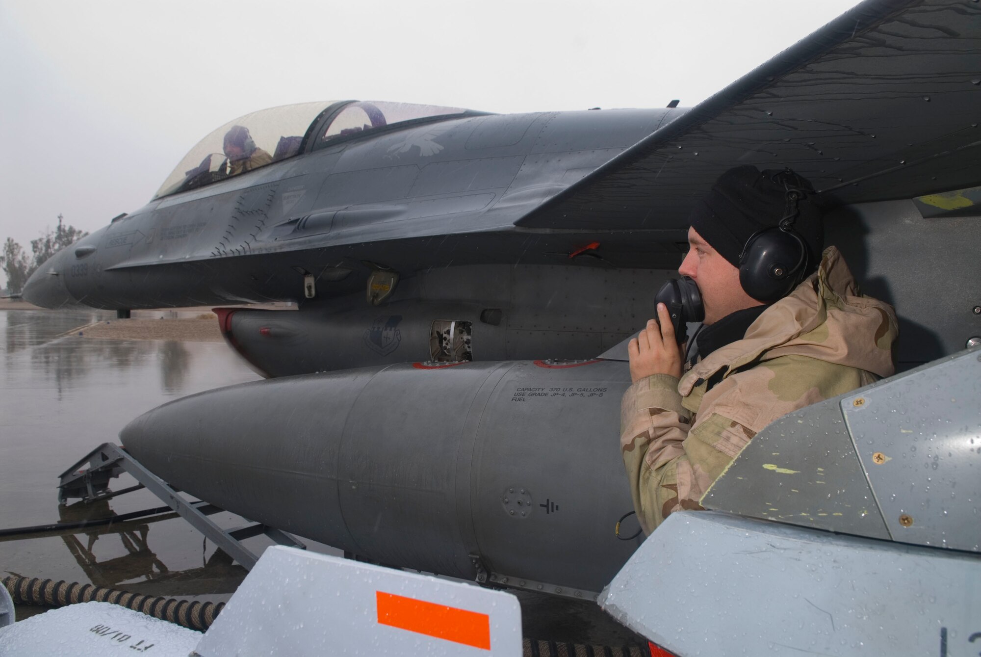 BALAD AIR BASE, Iraq -- Staff Sgt. Jeremy Crombie talks to Senior Airman Trevor Scott via radio headsets about the status of a global positioning system test here, Jan. 11. Sergeant Crombie and Airman Scott are 332nd Expeditionary Aircraft Maintenance Unit avionics technicians deployed from Spangdahlem Air Force Base, Germany. (U.S. Air Force photo/Staff Sgt. Joshua Garcia)