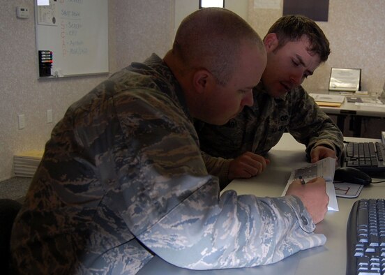 FORT BRAGG, N.C. - Air Force 1st Lts. Marc Quesnel and Adam Lazar review the Blue Force Tracker Techniques and Procedures Handbook while undergoing BFT training here. Lieutenant Quesnel, Team Paktia’s civil engineer, is deployed from Seymour Johnson Air Force Base, N.C. Lieutenant Lazar is deployed from Barksdale AFB, La., and serving as Team Zabul’s civil engineer. (U.S. Air Force photo/Capt. Ken Hall)