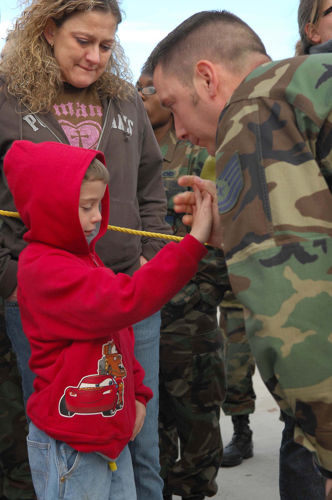 SHAW AIR FORCE BASE, S.C. -- Tech. Sgt David Skaggs, 20th Equipment Maintenance Squadron, gives his son Micah a high five as his wife Donna tearfully watches on before saying good bye prior to him boarding the plane for a deployment to the Pacific Air Forces theater Jan. 12. (U.S. Air Force Photo/Staff Sgt Henry L. Hoegen Jr.)