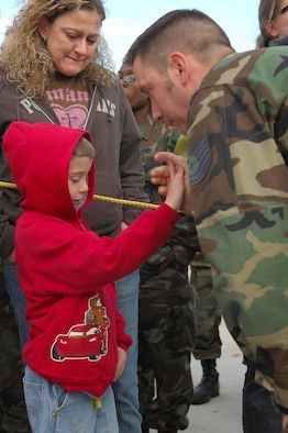 SHAW AIR FORCE BASE, S.C. -- Tech. Sgt David Skaggs, 20th Equipment Maintenance Squadron, gives his son Micah a high five as his wife Donna tearfully watches on before saying good bye prior to him boarding the plane for a deployment to the Pacific Air Forces theater Jan. 12. (U.S. Air Force Photo/Staff Sgt Henry L. Hoegen Jr.)