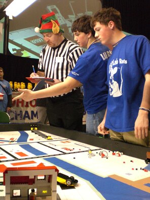 LEGO Lab Rats team members Justin Mullaney, of McNicholas High School, and C.J. Howitt of St. Xavier High School, Cincinnati, review their robot's success performing various tasks with referee Dave Parker during the FIRST LEGO League Ohio State Robotics Championship.  The 2008 event, co-sponsored by the Wright-Patterson Air Force Base Educational Outreach Office, brought together 48 teams of students and mentors from across the state to demonstrate their knowledge of environmental issues.  The competition was held Jan. 12-13 at Wright State University.  Parker works in the Air Force Materiel Command Information Assurance Office at Wright-Patt.  (U.S. Air Force photo/Derek Kaufman)
