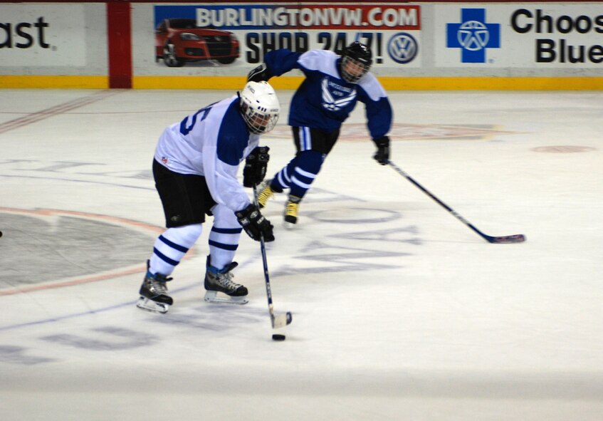 Dover Air Force Base's Ray Holland drives the puck past McGuire during the first all-star charity hockey challenge in 2008. That match ended with a Dover victory. The McGuire team won the second match in 2009, and the tie-breaker game is in Philadelphia March 28. (U.S. Air Force photo/Staff Sgt. Steve Lewis)
