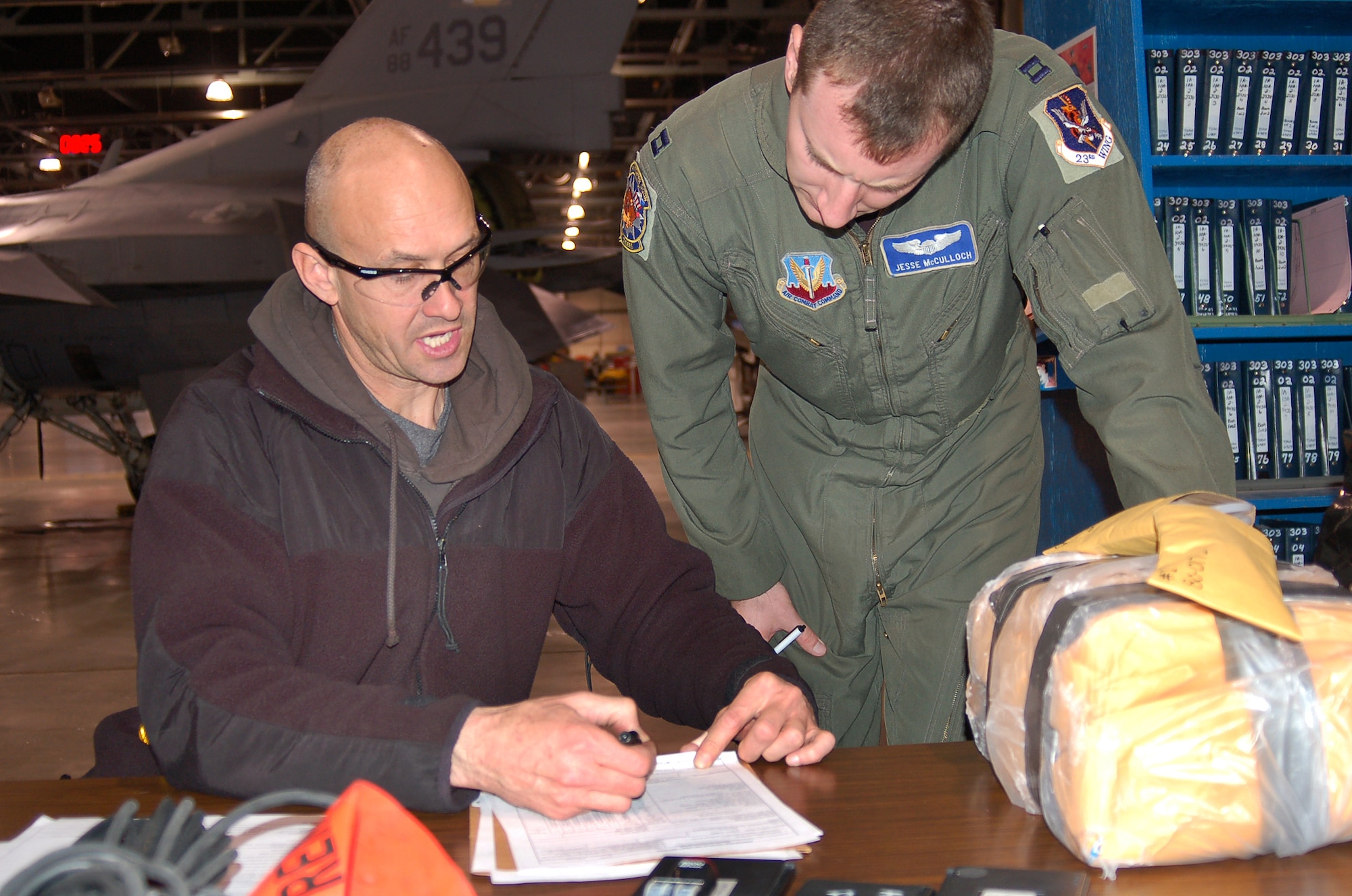 Final paperwork to send Aircraft 80-0172 to Moody AFB, Ga., is discussed by Andrew Selph, A-10 Flight Test, and Capt. Jesse McCulloch. The aircraft is the 100th to receive the Precision Engagement modification, installed by the 571st Aircraft Maintenance Squadron. (U.S. Air Force photo by Bill Orndorff)
