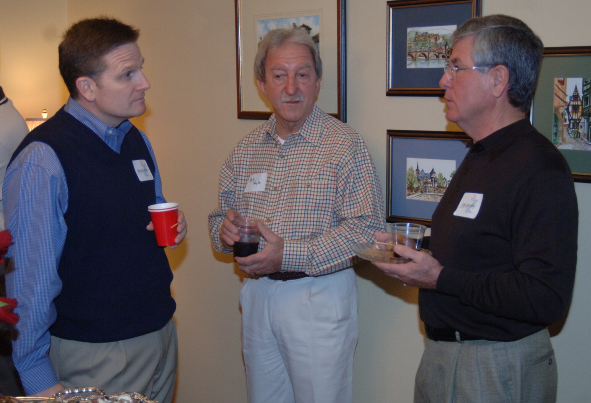 Colonel Jeff Dunn, 14th Flying Training Wing vice commander, Bob Taylor, 14th Security Forces Squadron honorary commander, and Leon Ellis, 14th Mission Support Group honorary commander, talk over drinks Saturday during the New Year’s reception at Col. Dave Gerber’s home.  (U.S. Air Force photo by Airman 1st Class Danielle Hill)
