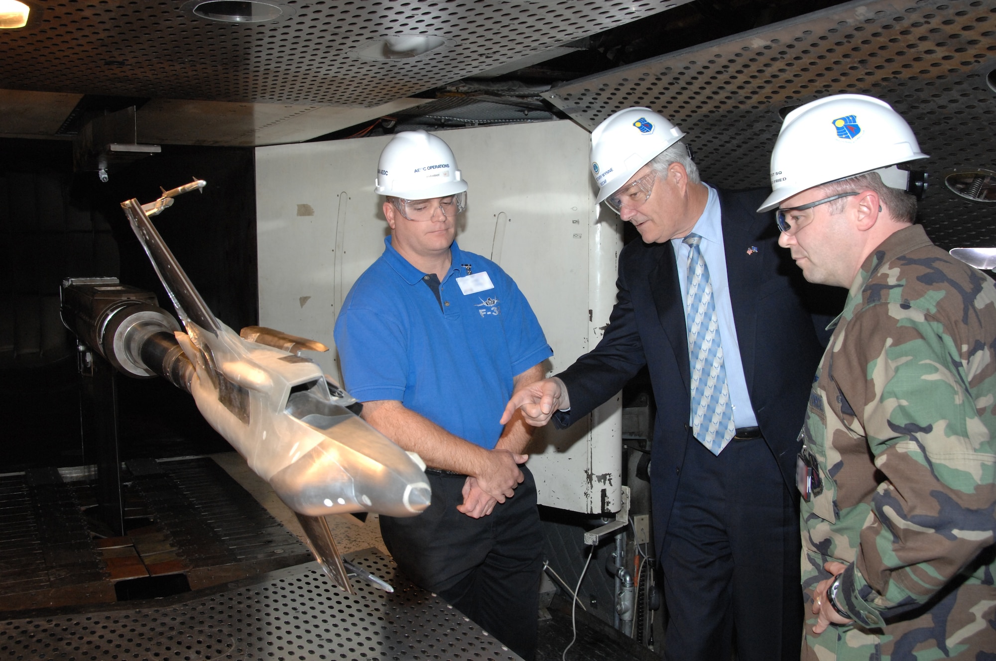 Secretary of the Air Force Michael W. Wynne asks questions about the models being used to conduct F-35 Lightning II store separation testing in the Arnold Engineering Development Center’s (AEDC) four-foot transonic wind tunnel. Capt. Rod Fried, Air Force flight systems test manager with AEDC’s 716th Test Squadron, and F-35 Store Separation Engineer Chris Hetreed with Lockheed Martin, were on hand to answer questions during Secretary Wynne’s first visit to the center Nov. 27, 2007. (Photo by David Housch)
