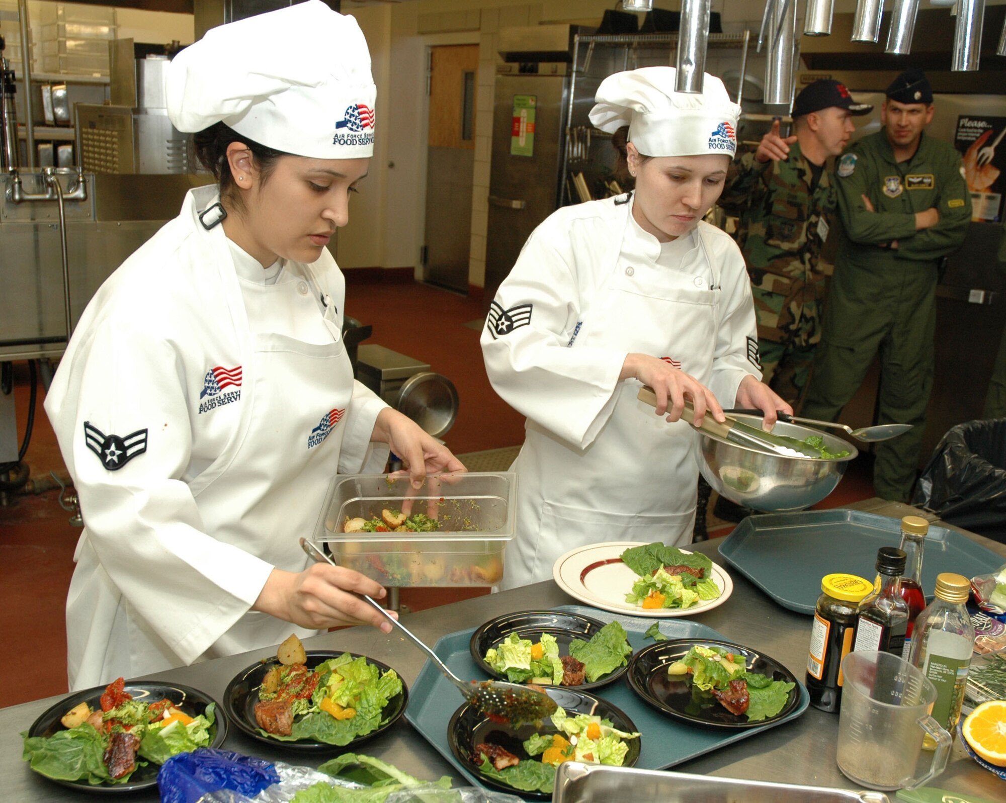 Airman 1st Class Gina Garcia, 564th Missile Squadron missile chef, and Staff Sgt. Megan Crusher, 564th MS senior missile chef, prepare citrus rosemary pork loin with new potato medley and citrus almond salad during the quarterly Warrior Chef competition at the Elkhorn Dining Facility Jan. 10. The 490th Missile Squadron team won the competition. (U.S. Air Force photo/Airman 1st Class Dillon White)