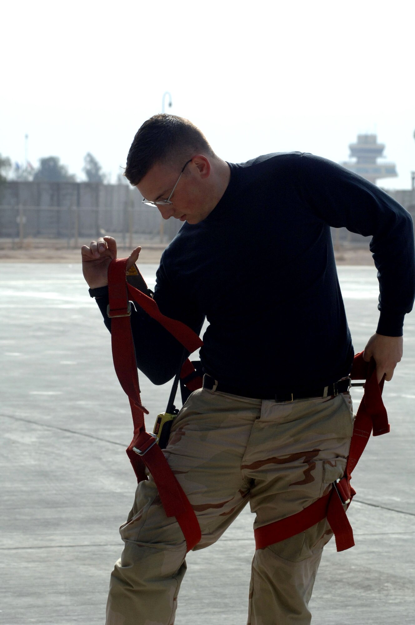 Staff Sgt. Charlton Packham puts on a safety harness before using a condor lift to perform maintenance on a C-5 Galaxy here. The C-5 can carry up to 36 standard pallets and 81 troops simultaneously. Sergeant Packham is a 721st Air Mobility Operations Group Det. 5 maintainer deployed from Travis Air Force Base, Calif. (U.S. Air Force photo/Senior Airman Terri Barriere) 
