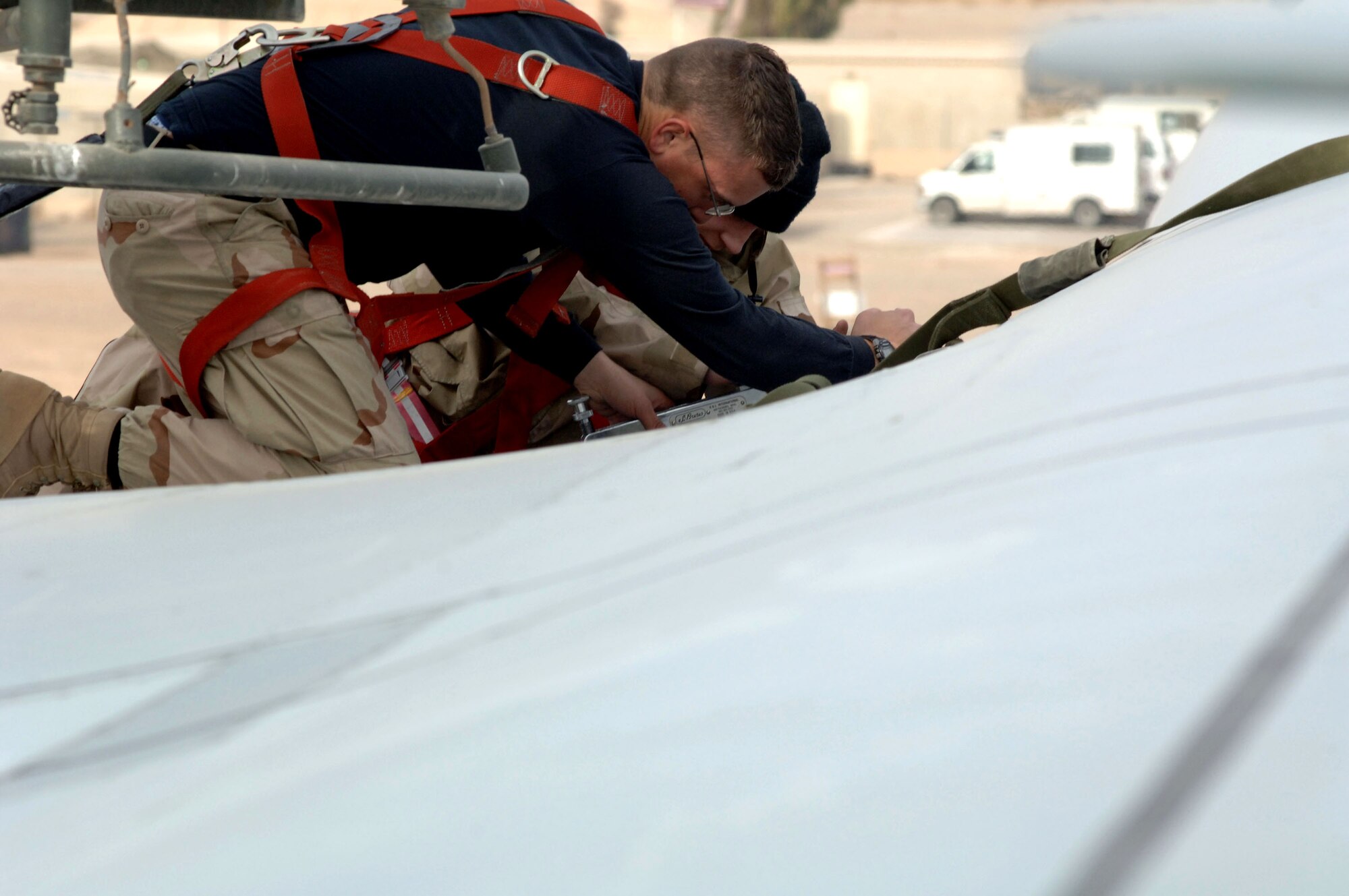 Staff Sgt. Charlton Packham and Airman 1st Class Chris Olmstead remove screws from a C-5 Galaxy Jan. 12 at Balad Air Base, Iraq. Both Airmen are 721st Air Mobility Operations Group Det. 5 maintainers and deployed from Travis Air Force Base, Calif. (U.S. Air Force photo/Senior Airman Terri Barriere) 
