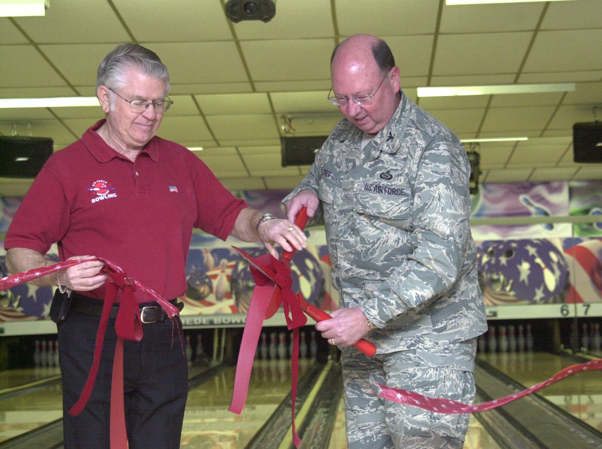 Jesse Davis, Thede Bowling Center manager, and Col. Richard Ayres, 17th Training Wing commander, cut the ribbon and officially open the new pin machines for use. The dedication was followed, appropriately, by an informal bowling tournament. (U.S. Air Force photo by Airman 1st Class Stephen Musal)