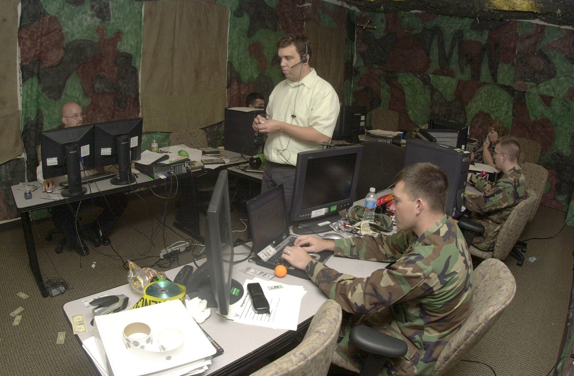Cory Lelek (far left), Jimmy Phillips (center wearing headset), 1st Lt. Ross Davis (typing on laptop at bottom right) and other members of the 17th Comptroller Squadron financial analysis flight work hard during the 2007 End-of-Year closeout Sept. 28, 2007. The 17 CPTS conference room was transformed into a "War Room" for the closeout. (U.S. Air Force photo by Senior Airman Luis Loza Gutierrez)