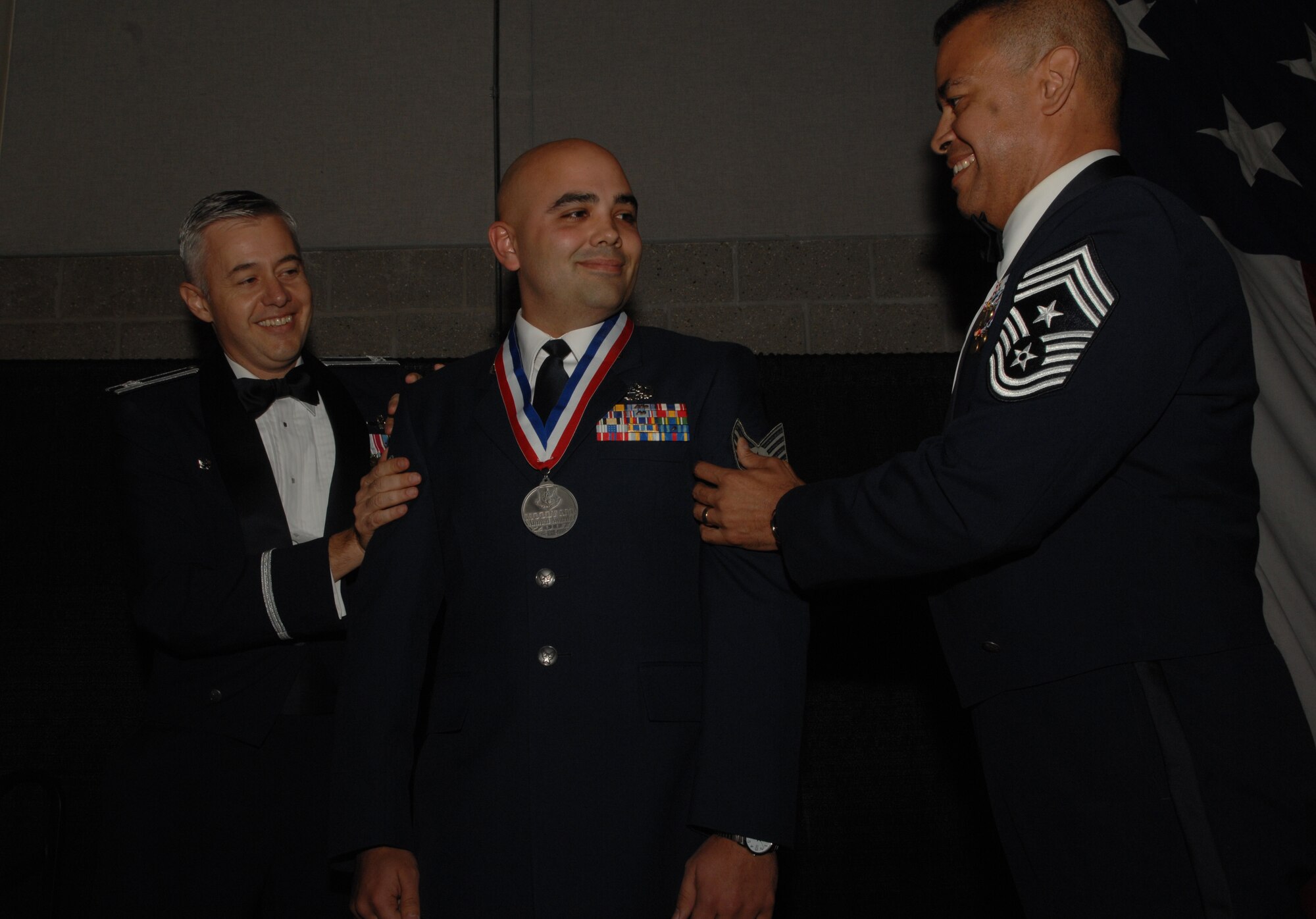 MOODY AIR FORCE BASE, Ga. -- Staff Sgt. Michael Ragains, center, gets step promoted to technical sergeant by Col. Kenneth Todorov and Command Chief Master Sgt. Paul Burgess at the Moody Air Force Base Annual Awards ceremony Jan 12. Ragains is with the 23rd Aircraft Maintenance Squadron at Pope Air Force Base, N.C. (U.S. Air Force photo by Airman 1st Class Gina Chiaverotti)