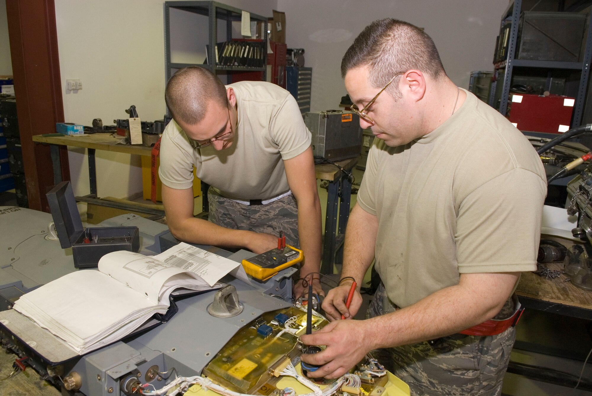 BALAD AIR BASE, Iraq -- Senior Airman Brandon Dutton and Tech. Sgt. Patrick Southard, both 332nd Expeditionary Maintenance Squadron weapons armament technicians, troubleshoot a Bomb Rack Unit-57 here, Jan. 14. The BRU-57 electrical system needs to be maintained to be serviceable for missions. Airman Dutton is deployed from Luke Air Force Base, Ariz. and Sergeant Southard is deployed from Spangdahlem Air Base, Germany. (U.S. Air Force photo/Staff Sgt. Joshua Garcia)