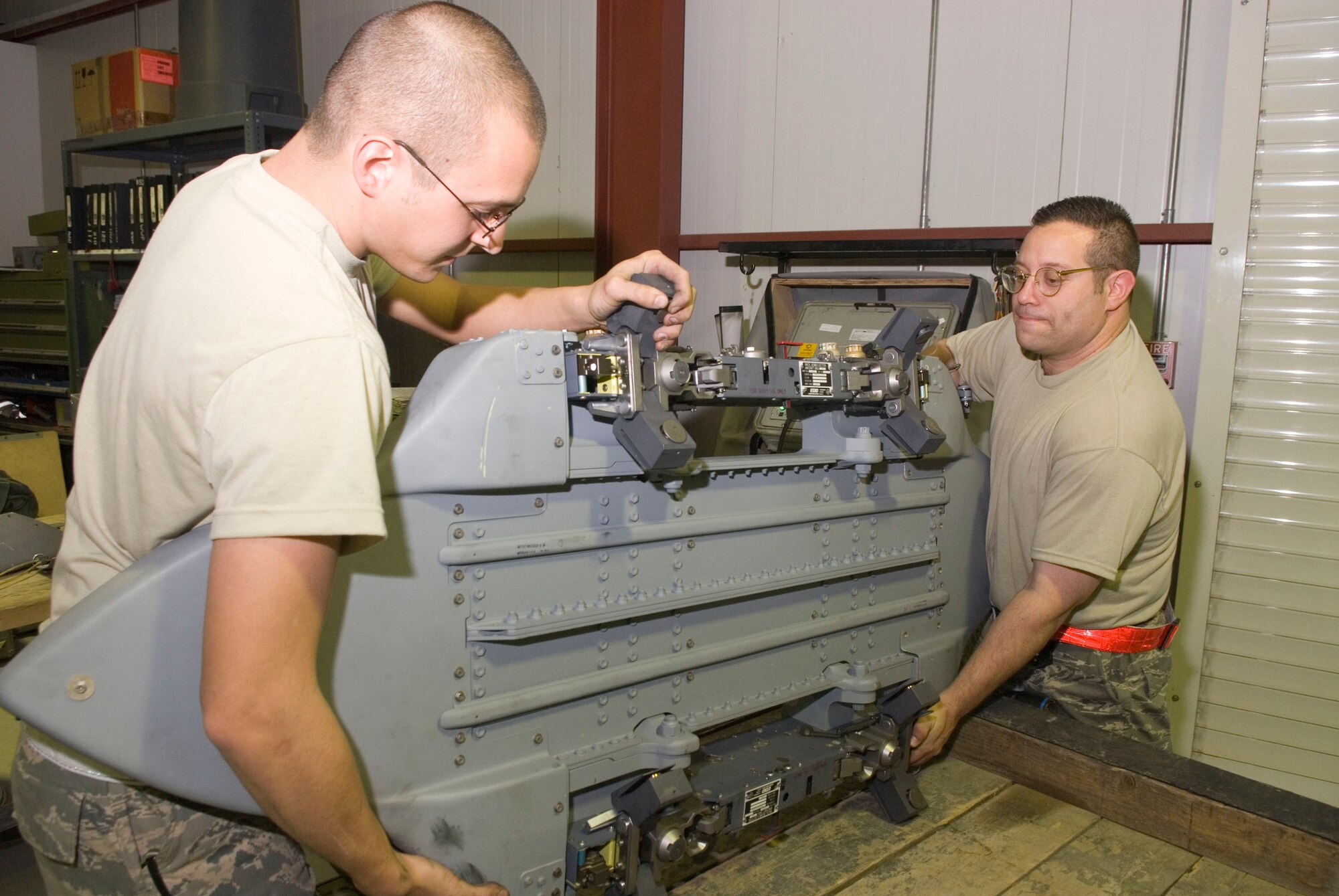 BALAD AIR BASE, Iraq -- Senior Airman Brandon Dutton and Tech. Sgt. Patrick Southard, both 332nd Expeditionary Maintenance Squadron weapons armament technicians, perform maintenance on a Bomb Rack Unit-57 here, Jan. 14. Airman Dutton is deployed from Luke Air Force Base, Ariz. and Sergeant Southard is deployed from Spangdahlem Air Base, Germany. (U.S. Air Force photo/Staff Sgt. Joshua Garcia)