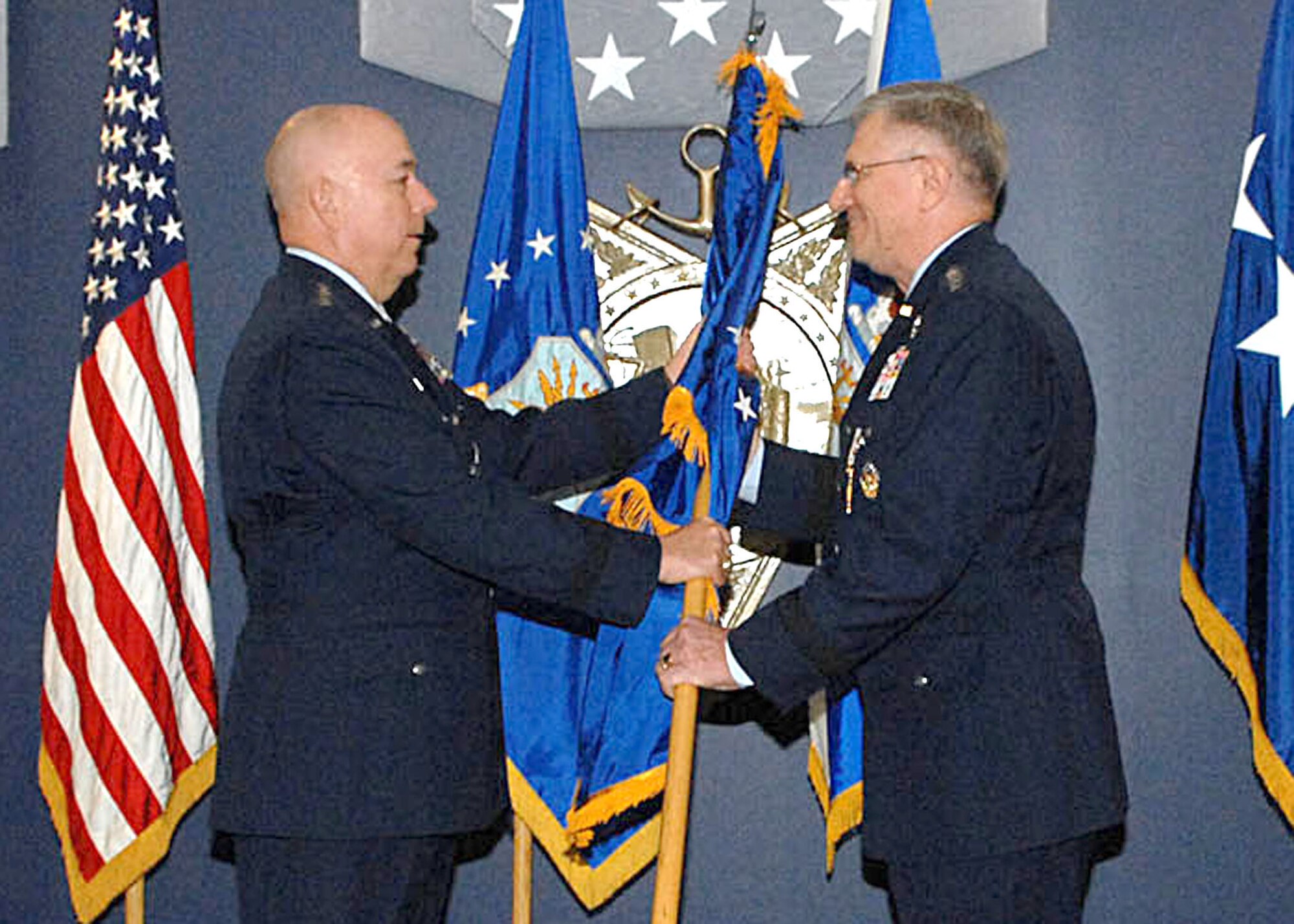 Chief of Staff of the Air Force Gen. T. Michael Moseley passes the U.S. Air Forces in Europe flag to new USAFE commander Gen. Roger A. Brady during an assumption-of-command ceremony Jan. 9 at the Pentagon. General Brady was also promoted to four-star general during the ceremony. (U.S. Air Force photo/Andy Morataya)