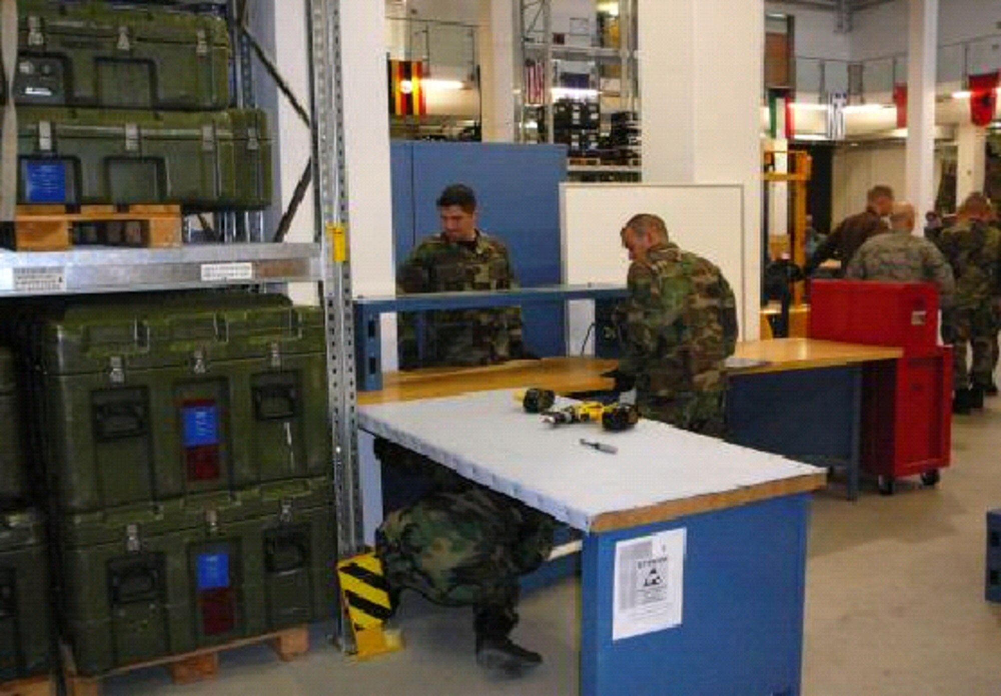 First Combat Communications Squadron AFSO 21 Rapid Improvement Event team members, technical sergeants Scott Dorphee and Jeff Isenberg, and Airman 1st Class Jeffery Fotakis design the work flow area for post-deployment inspections. (Courtesy photo)