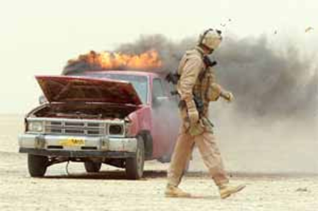 Marine Staff Sgt. Thomas R. Johnson, a platoon commander with Company C, 1st Light Armored Reconnaissance Battalion, Regimental Combat Team 2, walks away from a truck the company found in Rawah, Iraq, which was rigged with a detonation trigger and believed to be intended as a vehicle bomb. The company used fuel and an incendiary grenade to safely destroy the vehicle and deny its use against coalition forces. Photo by Cpl. Ryan C. Heiser, USMC