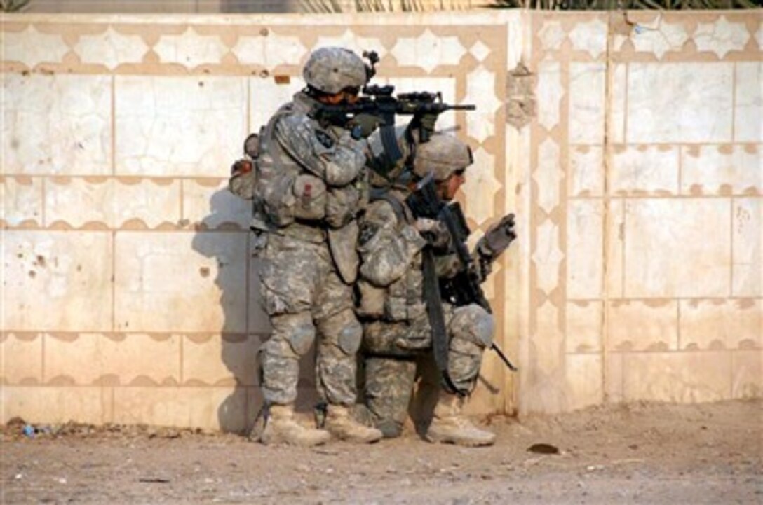 U.S. Army soldiers pause at a corner of a wall and scan for movement as they move through the town of Al Bajhama, Iraq, on Jan. 5, 2008.  The soldiers are from Alpha Co., 2d Battalion, 23rd Infantry Regiment, 4th Brigade Combat Team, 2nd Infantry Division.  