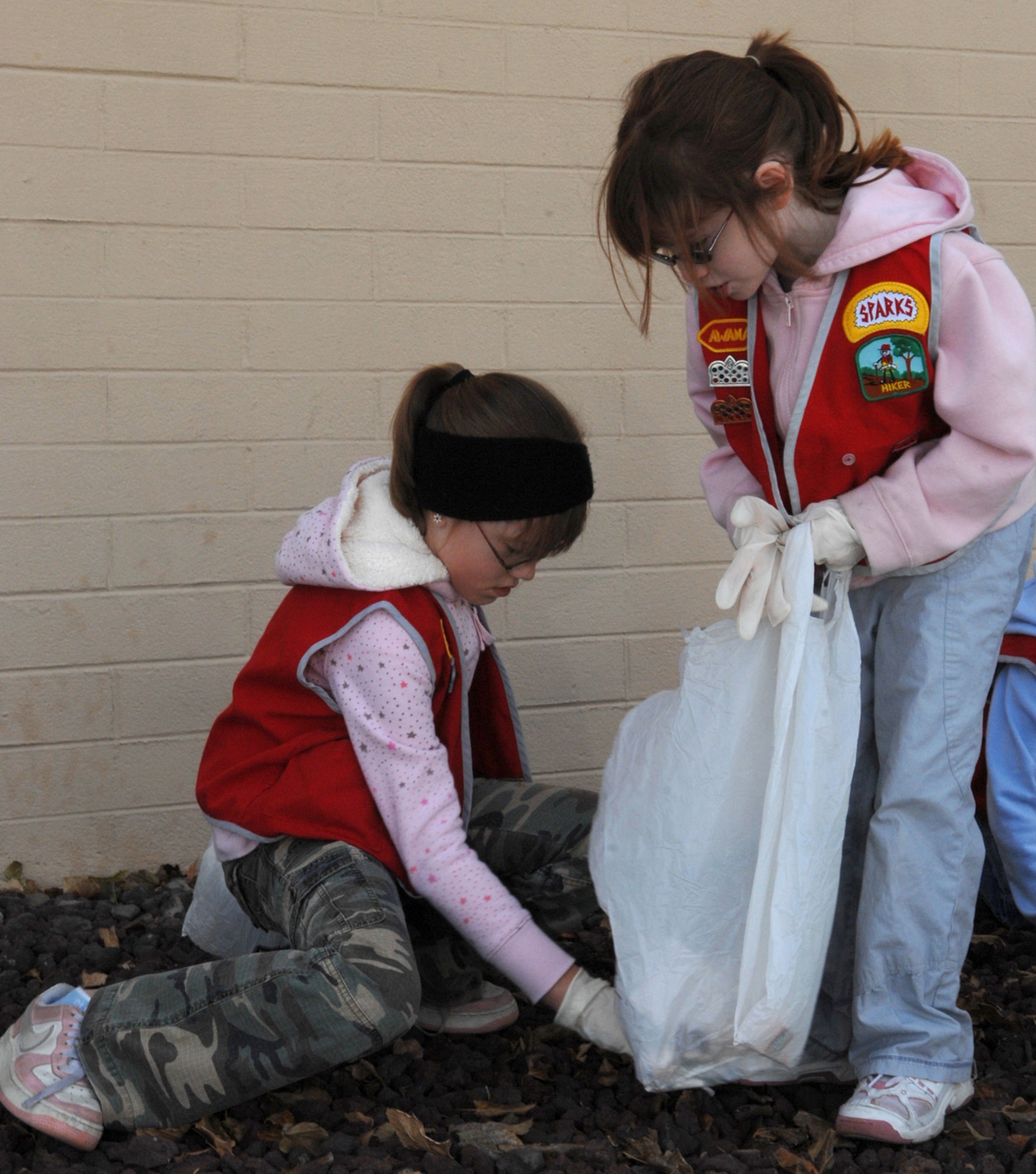 Emma and Jenna Papponetti, daughters of Staff Sgt. Scott Papponetti, 99th Ground Combat Training Squadron, clean up Nellis as part of a Approved Workmen Are Not Ashamed (AWANA) volunteer event dedicated to improving Nellis’ community appearance, Jan. 12. AWANA's is a religious youth group for children between ages two to 18, whose goal is to raise spiritual awareness among its members and seek out volunteer opportunities. (U.S. Air Force photo by Senior Airman Nadine Y. Barclay)