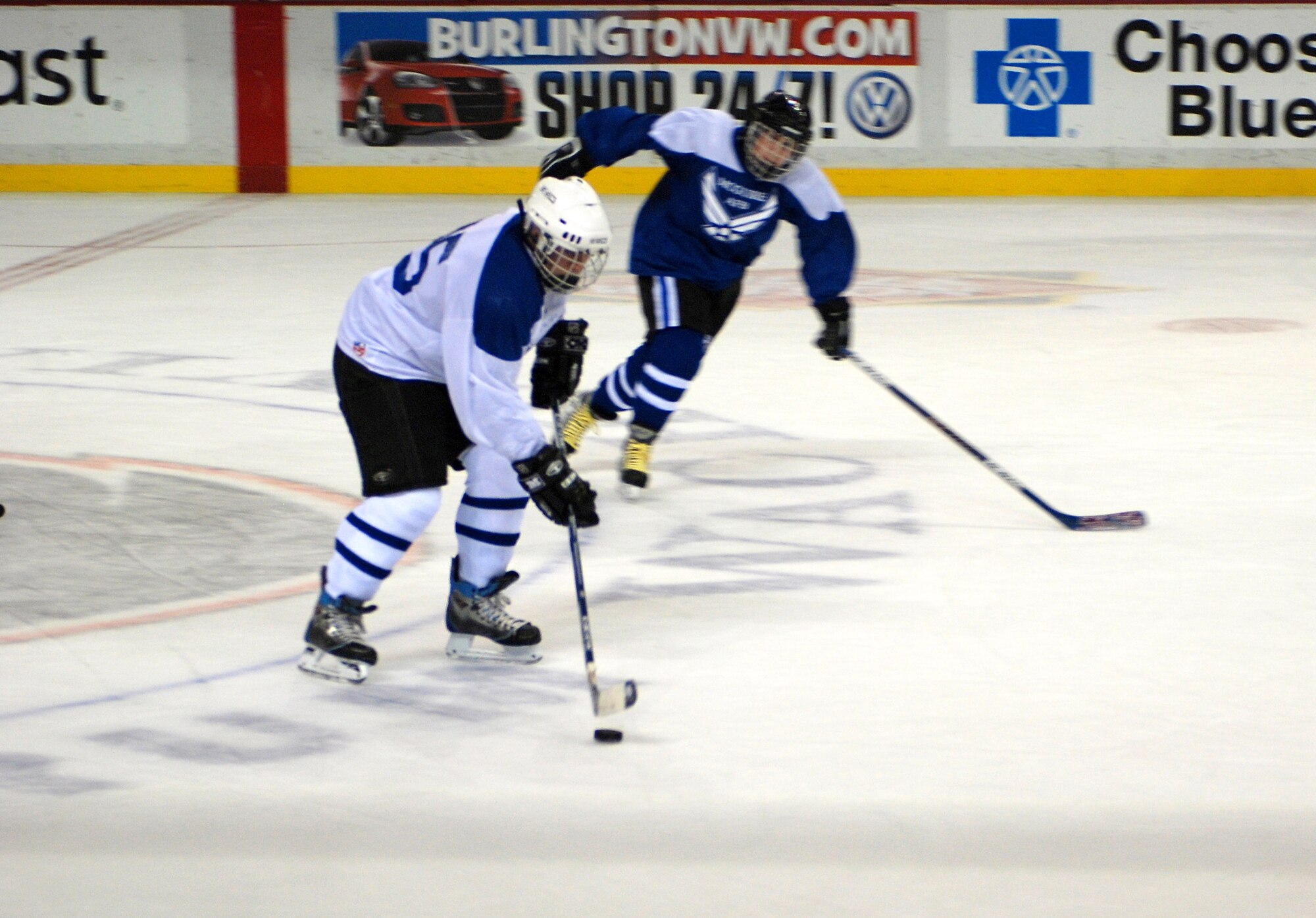 Ray Holland of the Dover Air Force Base, Del., team (left) drives the puck past a McGuire AFB, N.J., player during the all-star charity hockey challenge Jan. 13 in Philadelphia. The game ended with a Dover AFB victory, 9-4 as the teams raised $1,500 for the Combined Federal Campaign in the hockey match.  (U.S. Air Force photo/Staff Sgt. Steve Lewis) 
