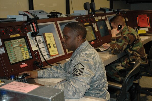 917th Wing Air Reserve Technician Master Sgt. John McClain and his active-duty counterpart, Senior AIrman Aaron Blair, perform flight-following operations at the Barksdale Command Post Friday, Jan. 11. (U.S. Air Force photo/Master Sgt. Sherri Bohannon)