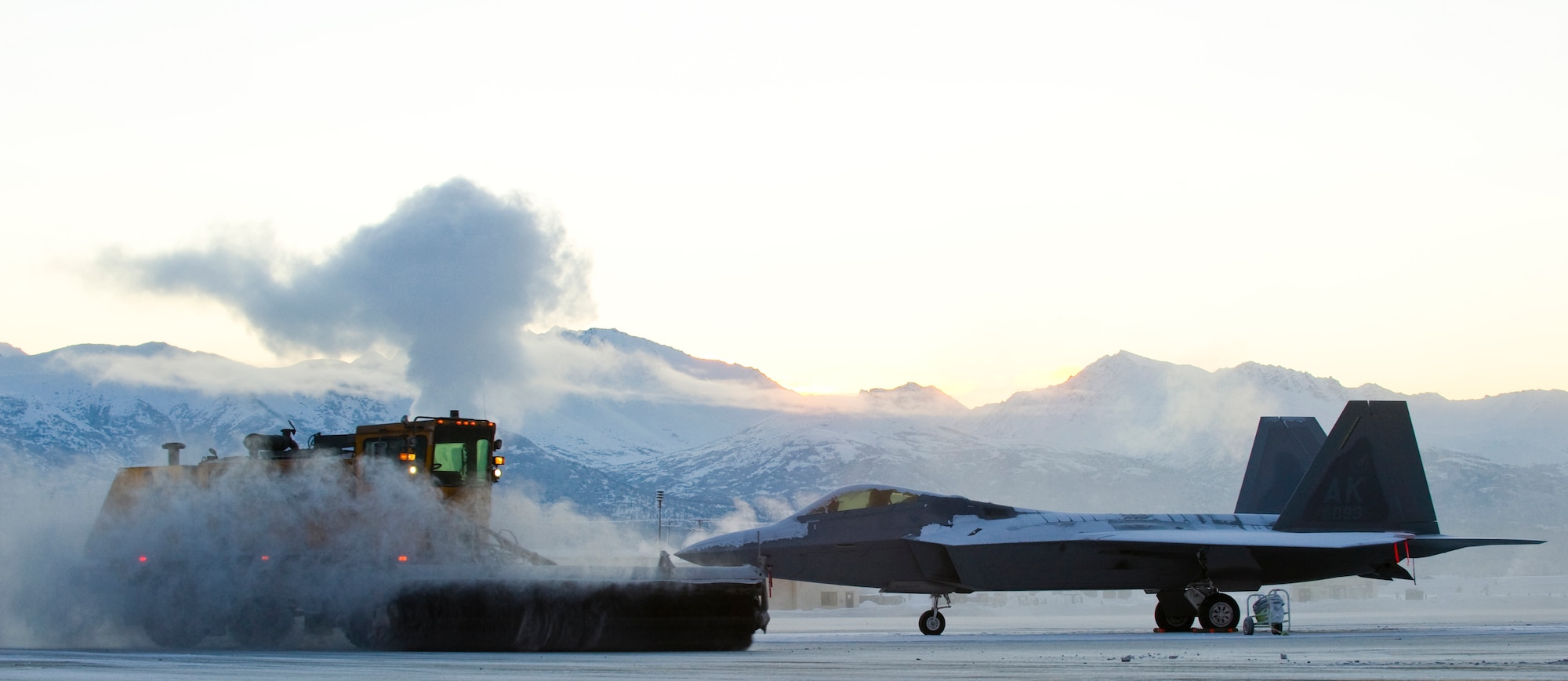 ELMENDORF AIR FORCE BASE, Alaska - The 3rd Civil Engineer Squadron Snow Removal flight maneuvers around a snow-covered F-22A Raptor to keep the runways cleared for Alaskan NORAD Region operations Jan. 13, 2008 at Elmendorf Air Force Base, Alaska. (U.S. Air Force photo/Senior Airman Garrett Hothan)