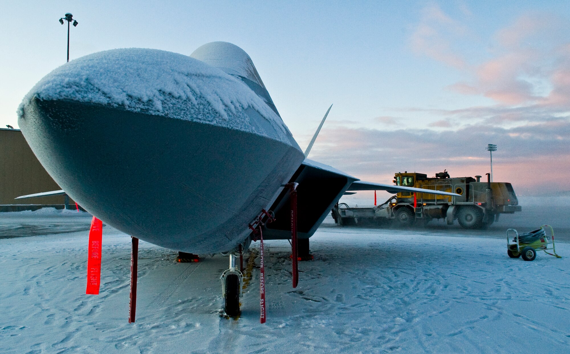 ELMENDORF AIR FORCE BASE, Alaska - A snow covered F-22A Raptor rests in a circle of snow as 3rd Civil Engineer Squadron Snow Removal members clear the runways Jan. 13, 2008. Elmendorf is the second operational base and the first in the Pacific Air Forces to have a permanent Raptor mission. (U.S. Air Force photo/Senior Airman Garrett Hothan)